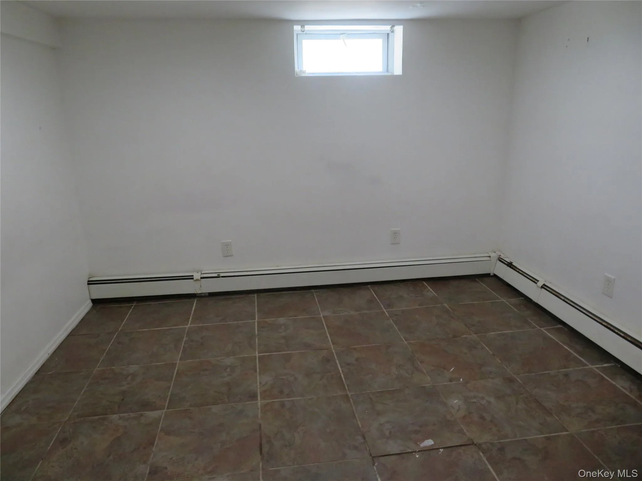 Room featuring white walls and square tile flooring Room featuring white walls and square tile flooring
