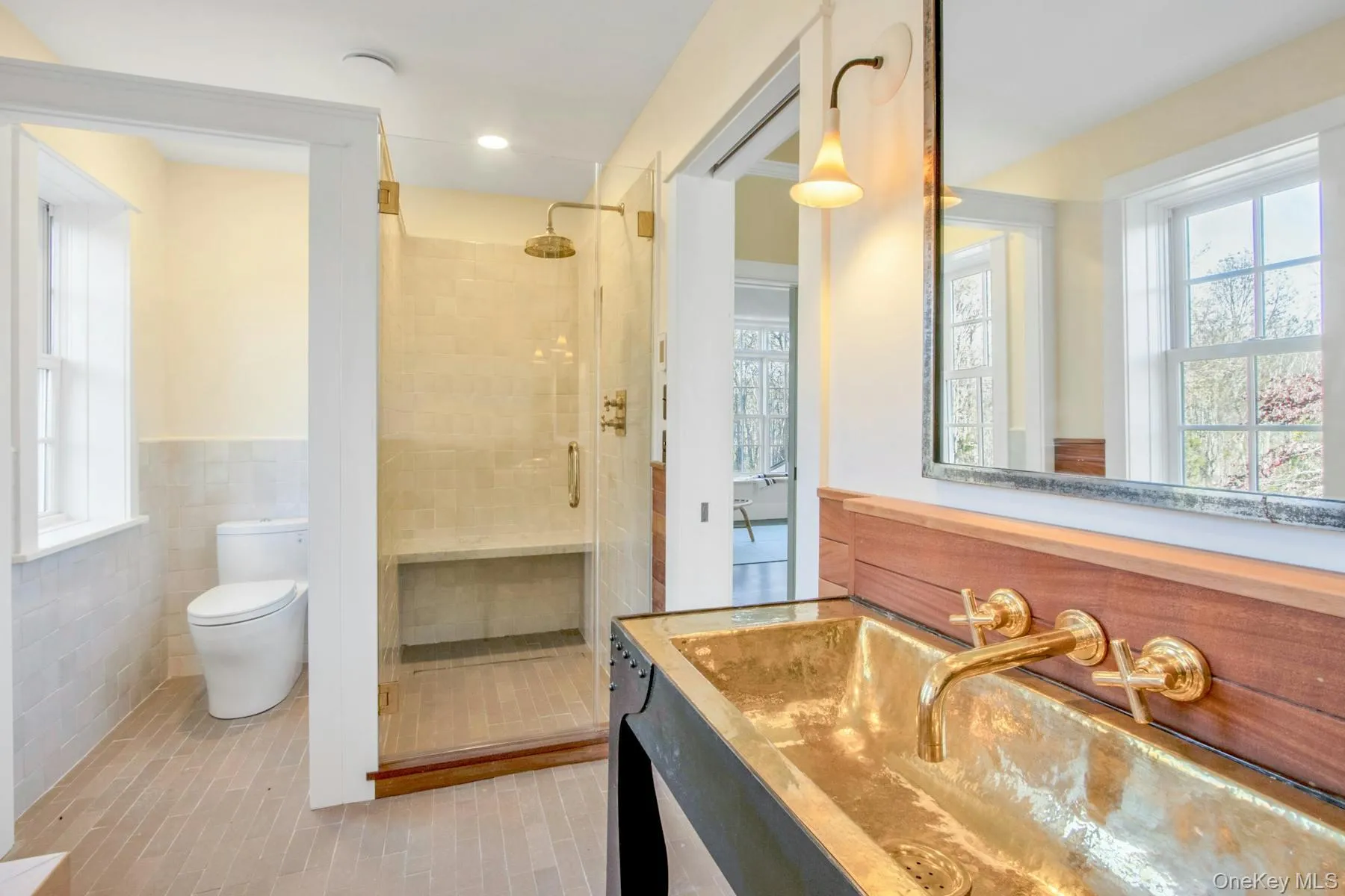 featuring a brass hammered sink and walk-in shower featuring a brass hammered sink and walk-in shower