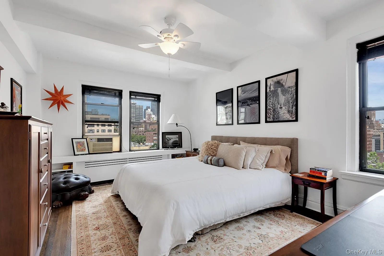 Bedroom with wood floors, ceiling fan, multiple windows, and beam ceiling Bedroom with wood floors, ceiling fan, multiple windows, and beam ceiling
