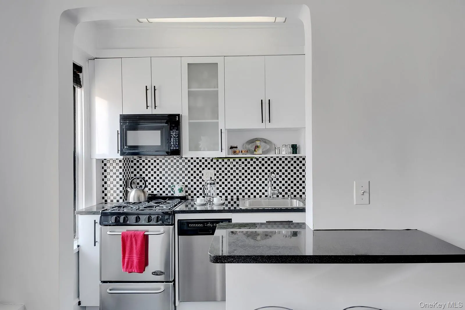 Kitchen with stainless steel appliances and white cabinetry Kitchen with stainless steel appliances and white cabinetry