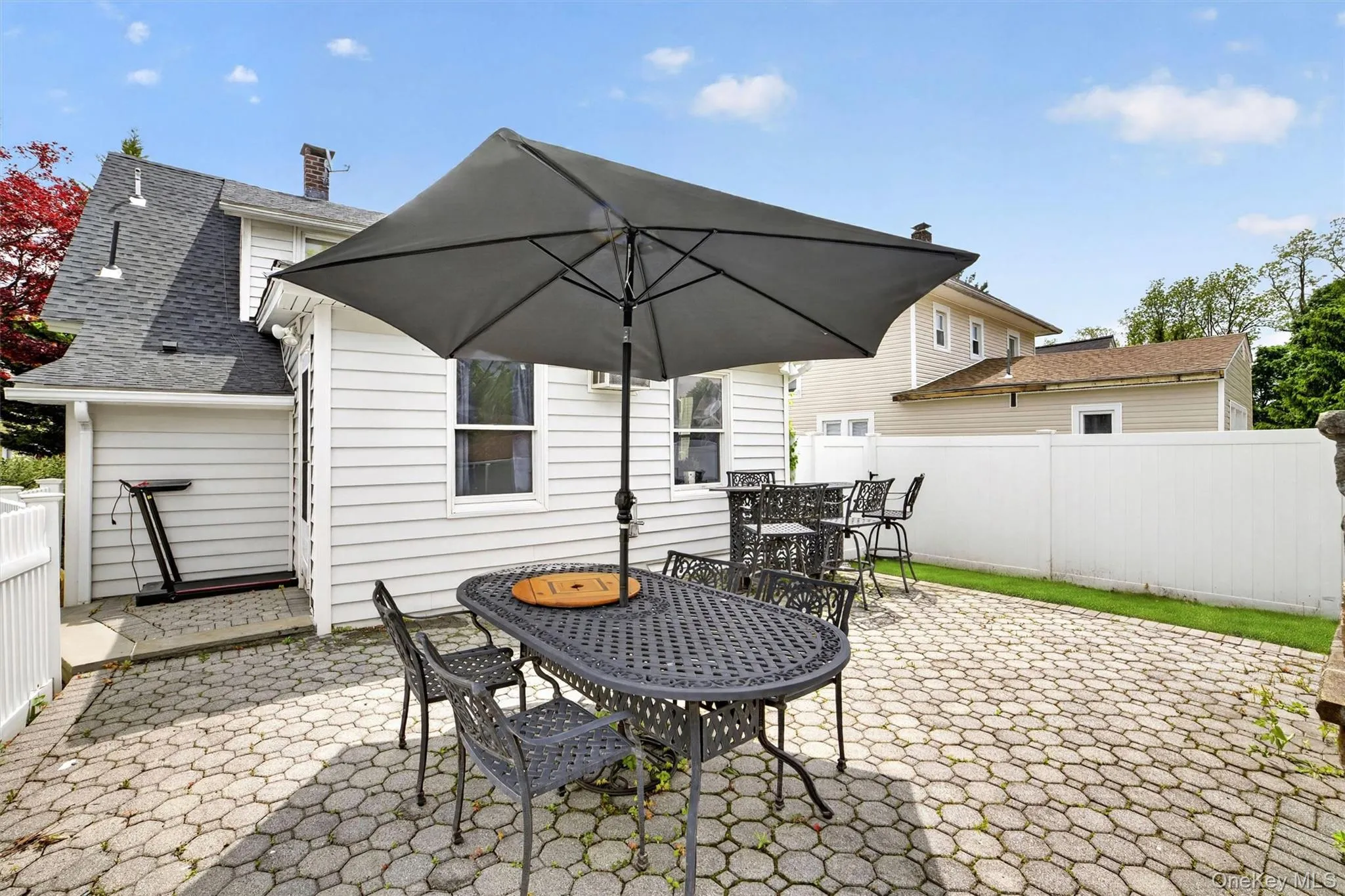 Expansive paver patio featuring a built-in stone oven and a dedicated pathway Expansive paver patio featuring a built-in stone oven and a dedicated pathway