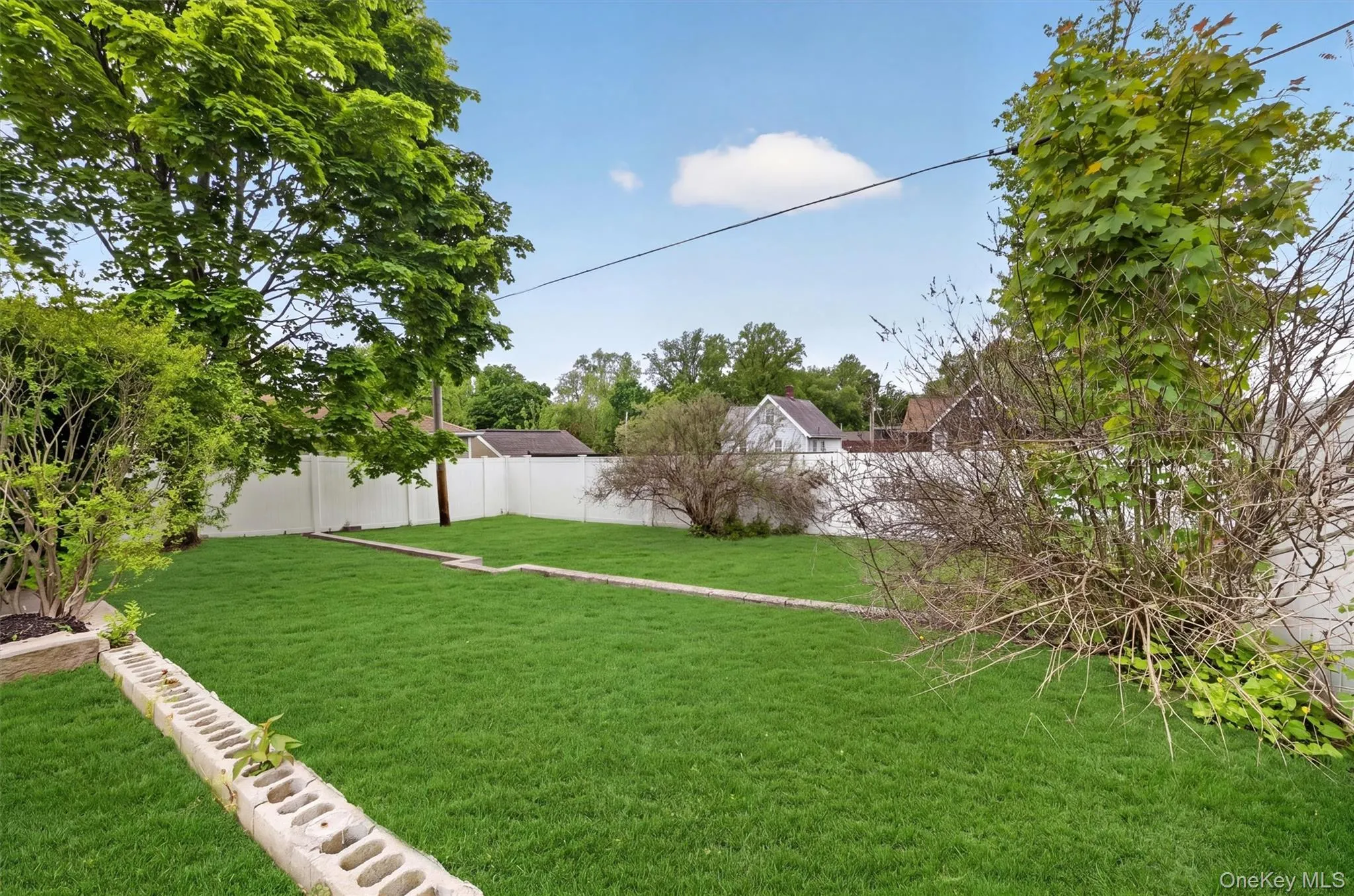 Expansive lawn area featuring a tiered design with concrete retaining walls. Expansive lawn area featuring a tiered design with concrete retaining walls.