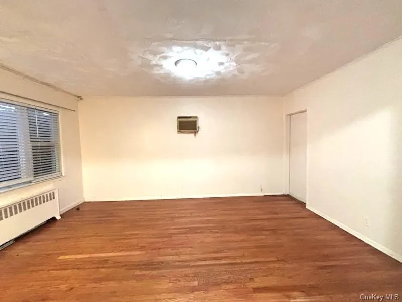 Spare room with wood finished floors and baseboards Spare room with wood finished floors and baseboards