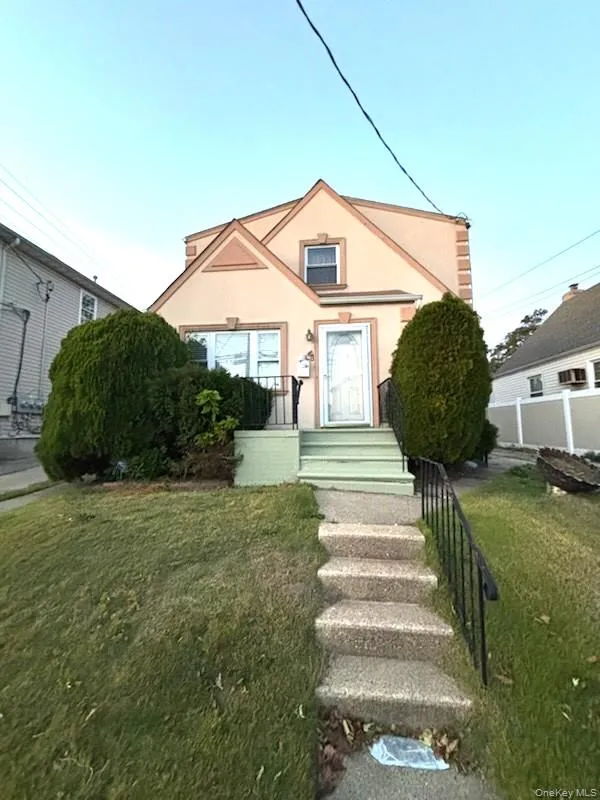 Bungalow with stucco siding and a front lawn Bungalow with stucco siding and a front lawn