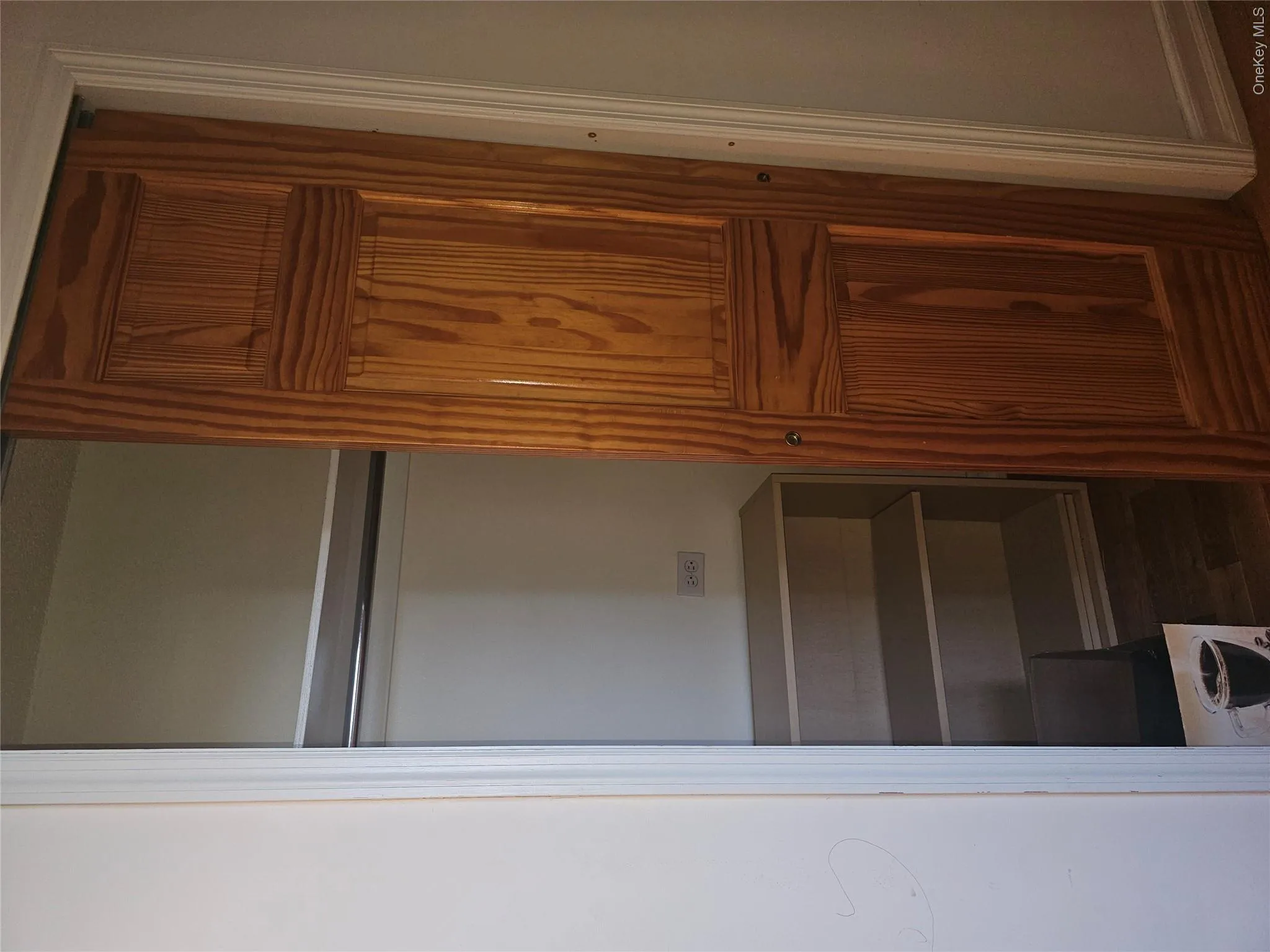 Custom wood-panel barn door entry to a closet featuring a chrome hanging rod, built-in shelving, and light wood-finish flooring Custom wood-panel barn door entry to a closet featuring a chrome hanging rod, built-in shelving, and light wood-finish flooring