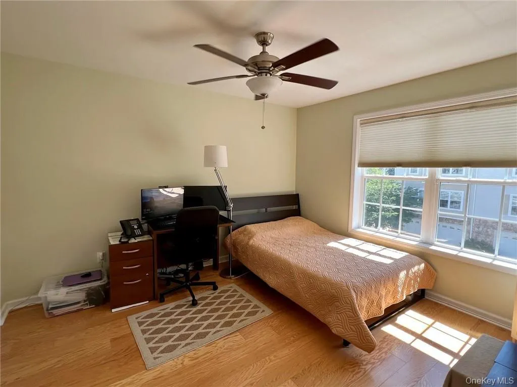 Bedroom #3 with wood finished floors, ceiling fan, baseboards, and an office area Bedroom #3 with wood finished floors, ceiling fan, baseboards, and an office area
