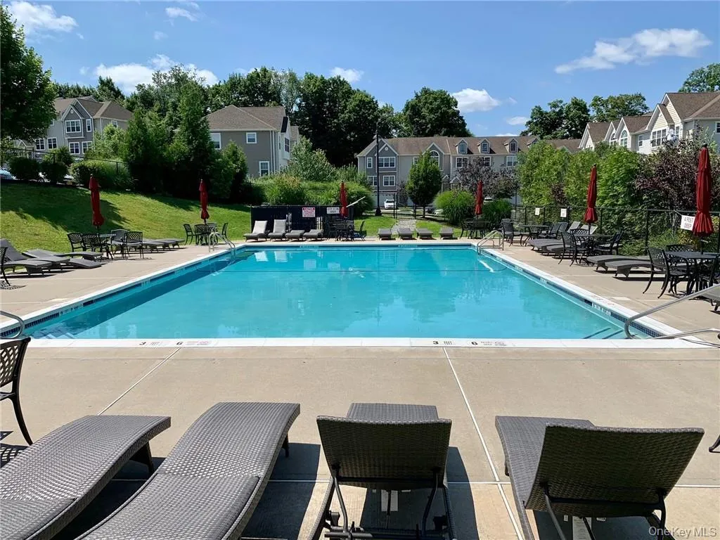Community pool featuring a patio, a residential view, and a lawn Community pool featuring a patio, a residential view, and a lawn