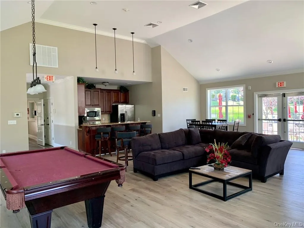 Clubhouse Recreation room with high vaulted ceiling, light wood finished floors, billiards table, and crown molding Clubhouse Recreation room with high vaulted ceiling, light wood finished floors, billiards table, and crown molding