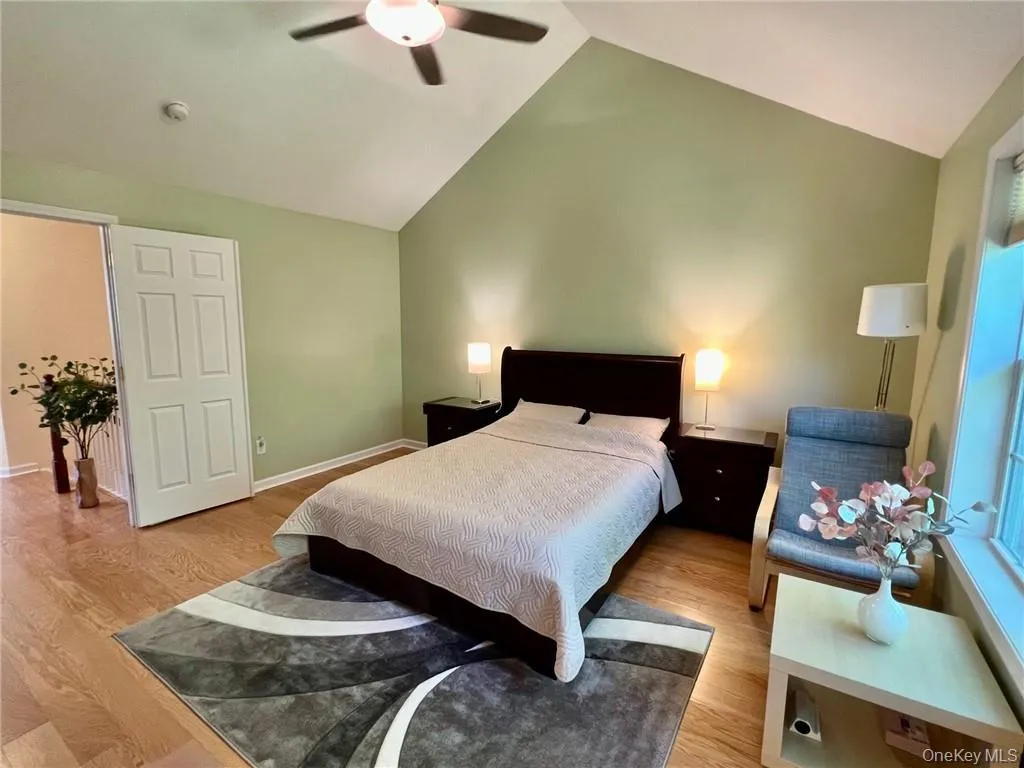 Primary Bedroom with lofted ceiling, light wood-style floors, baseboards, and ceiling fan Primary Bedroom with lofted ceiling, light wood-style floors, baseboards, and ceiling fan