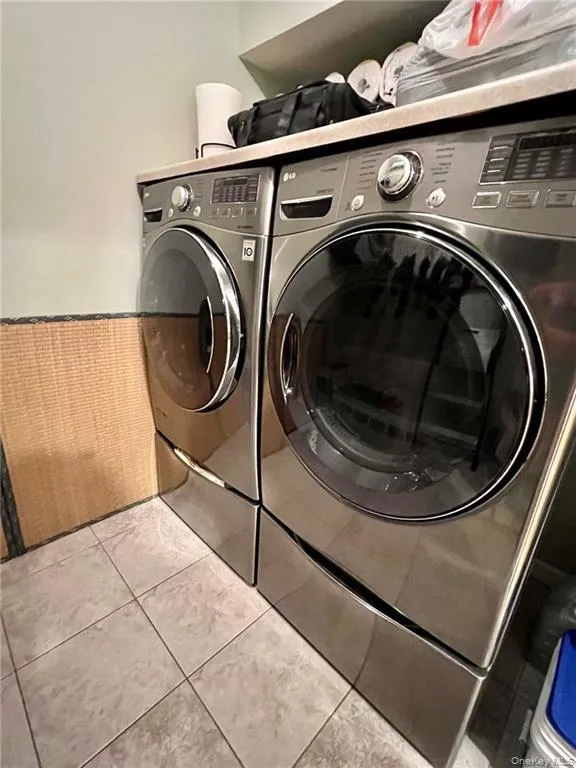 Laundry room featuring separate washer and dryer and tile patterned floors Laundry room featuring separate washer and dryer and tile patterned floors