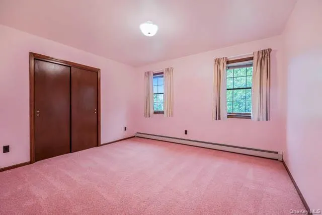 Carpeted interior space with two windows providing natural light Carpeted interior space with two windows providing natural light