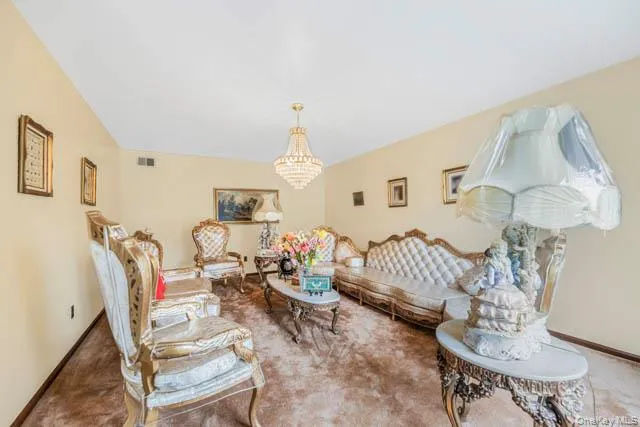 Spacious room featuring light-colored walls and a crystal chandelier Spacious room featuring light-colored walls and a crystal chandelier