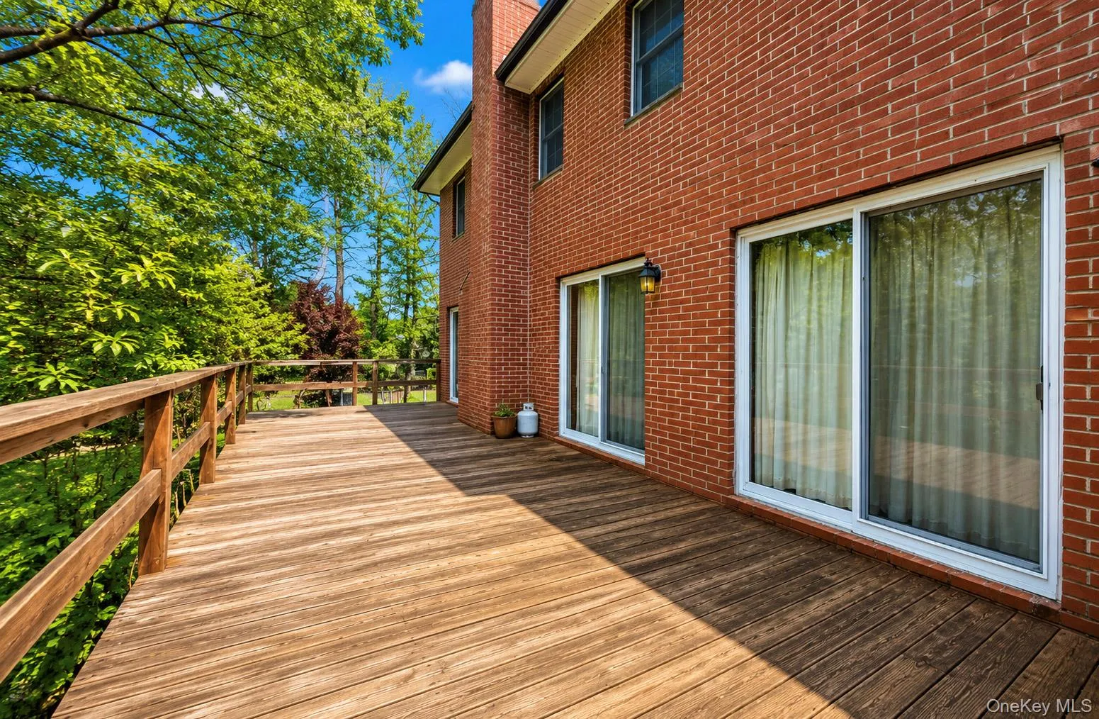 Expansive wood-finish deck with a wood railing system Expansive wood-finish deck with a wood railing system