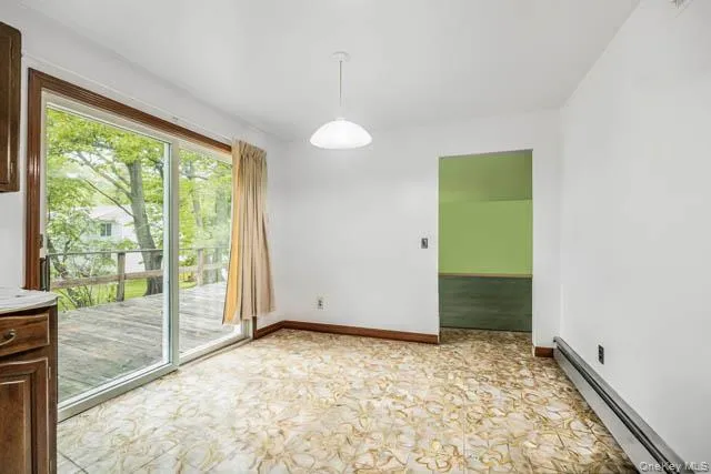Room featuring sliding glass doors opening to an exterior wood deck Room featuring sliding glass doors opening to an exterior wood deck