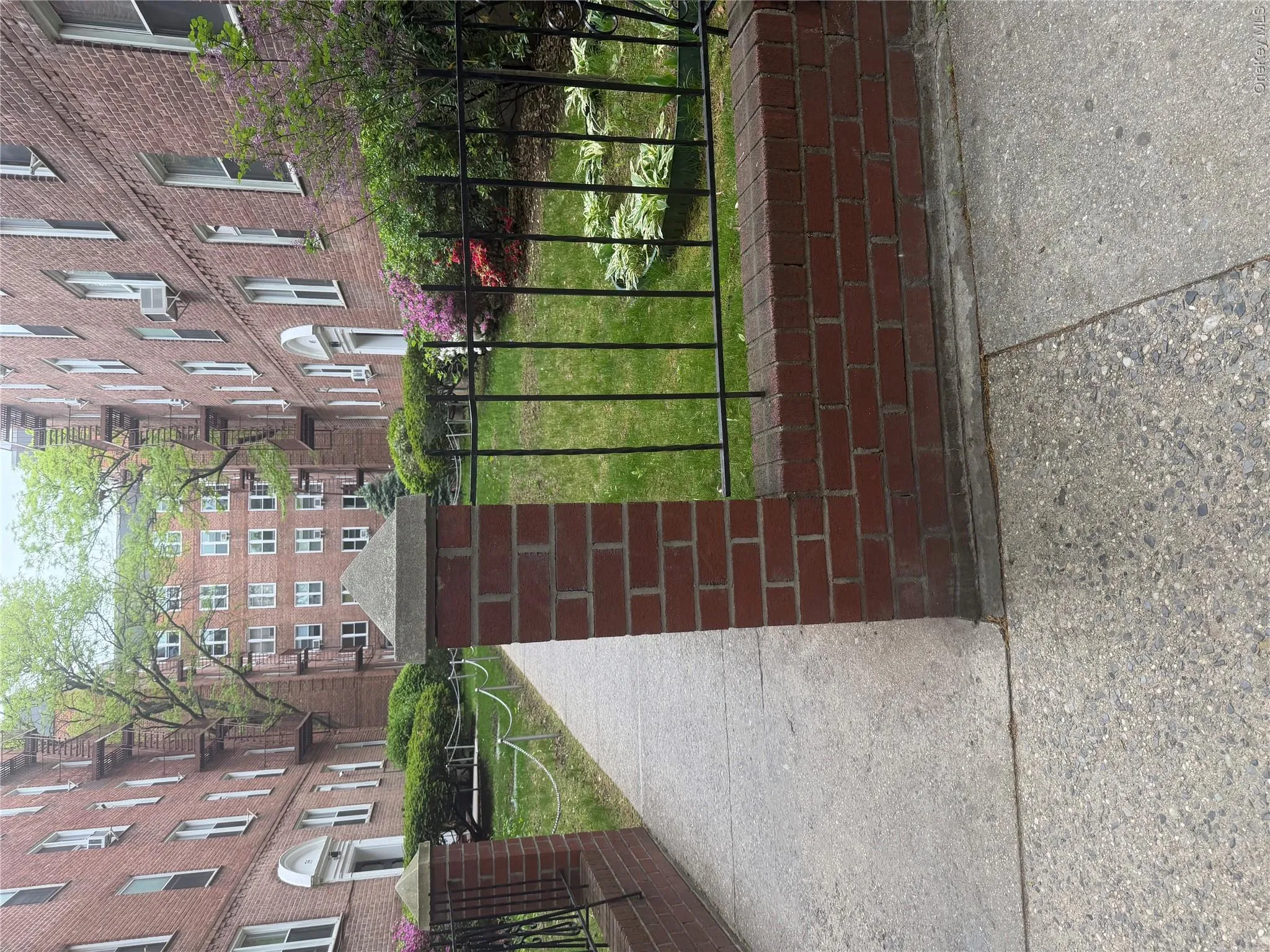 Brick apartment buildings with multiple levels, featuring uniform window placements and arched entryways Brick apartment buildings with multiple levels, featuring uniform window placements and arched entryways