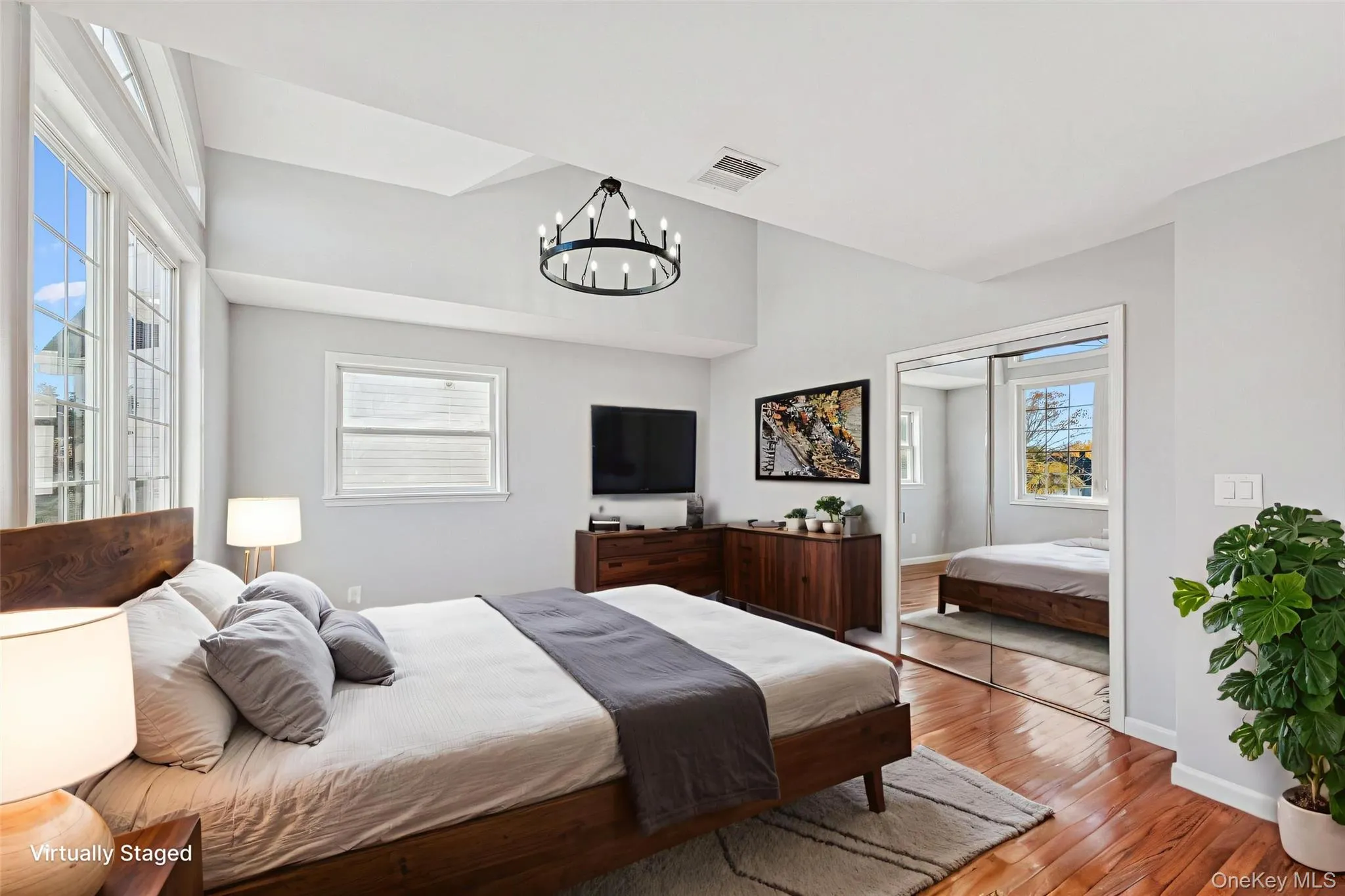 Second Floor Primary Bedroom with full en-suite and large closets with custom cabinets. Vaulted ceilings accent this room with wood-finish flooring Second Floor Primary Bedroom with full en-suite and large closets with custom cabinets. Vaulted ceilings accent this room with wood-finish flooring