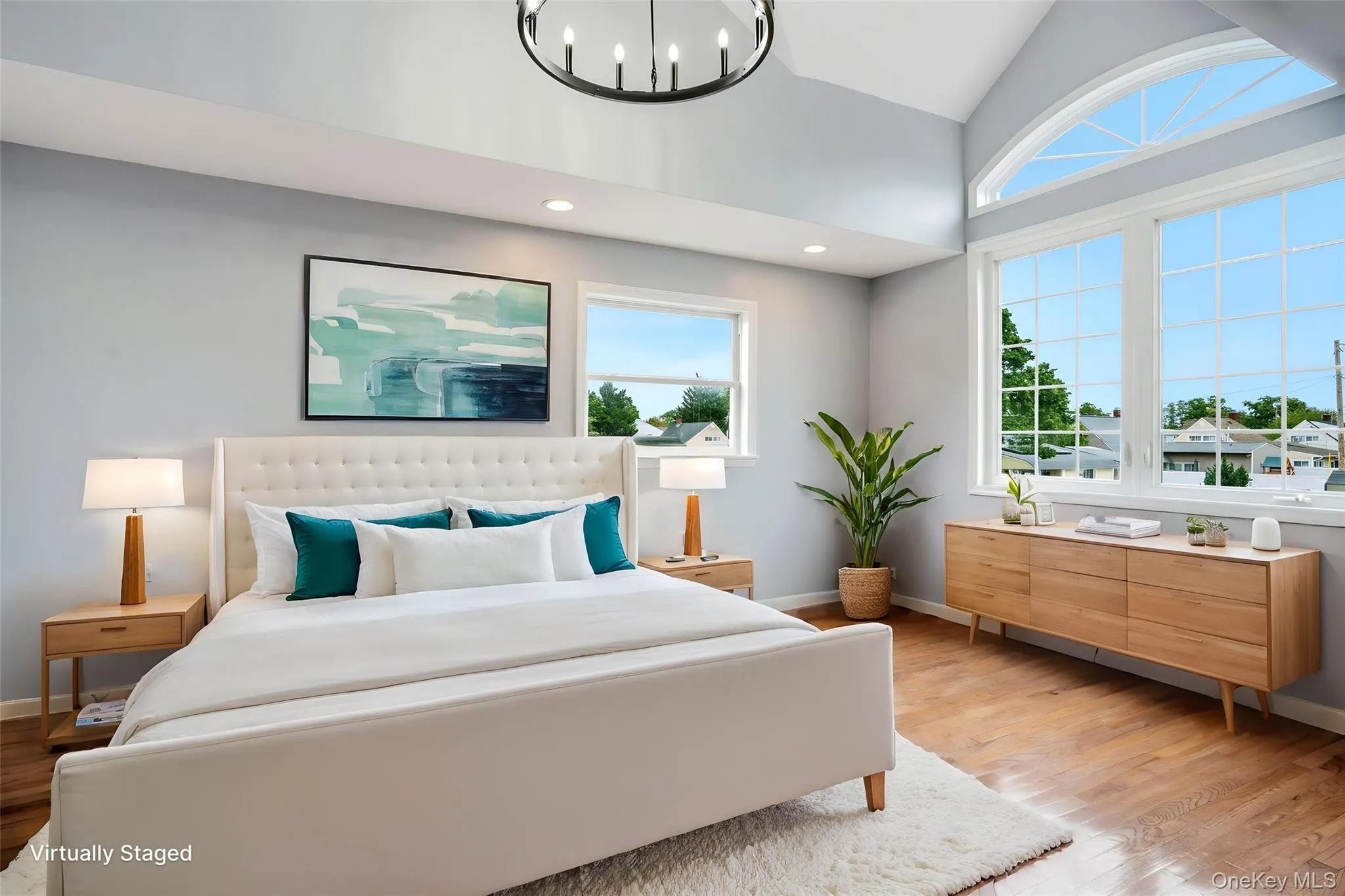Bedroom featuring vaulted ceilings with an arched window, hardwood flooring, and recessed lighting Bedroom featuring vaulted ceilings with an arched window, hardwood flooring, and recessed lighting
