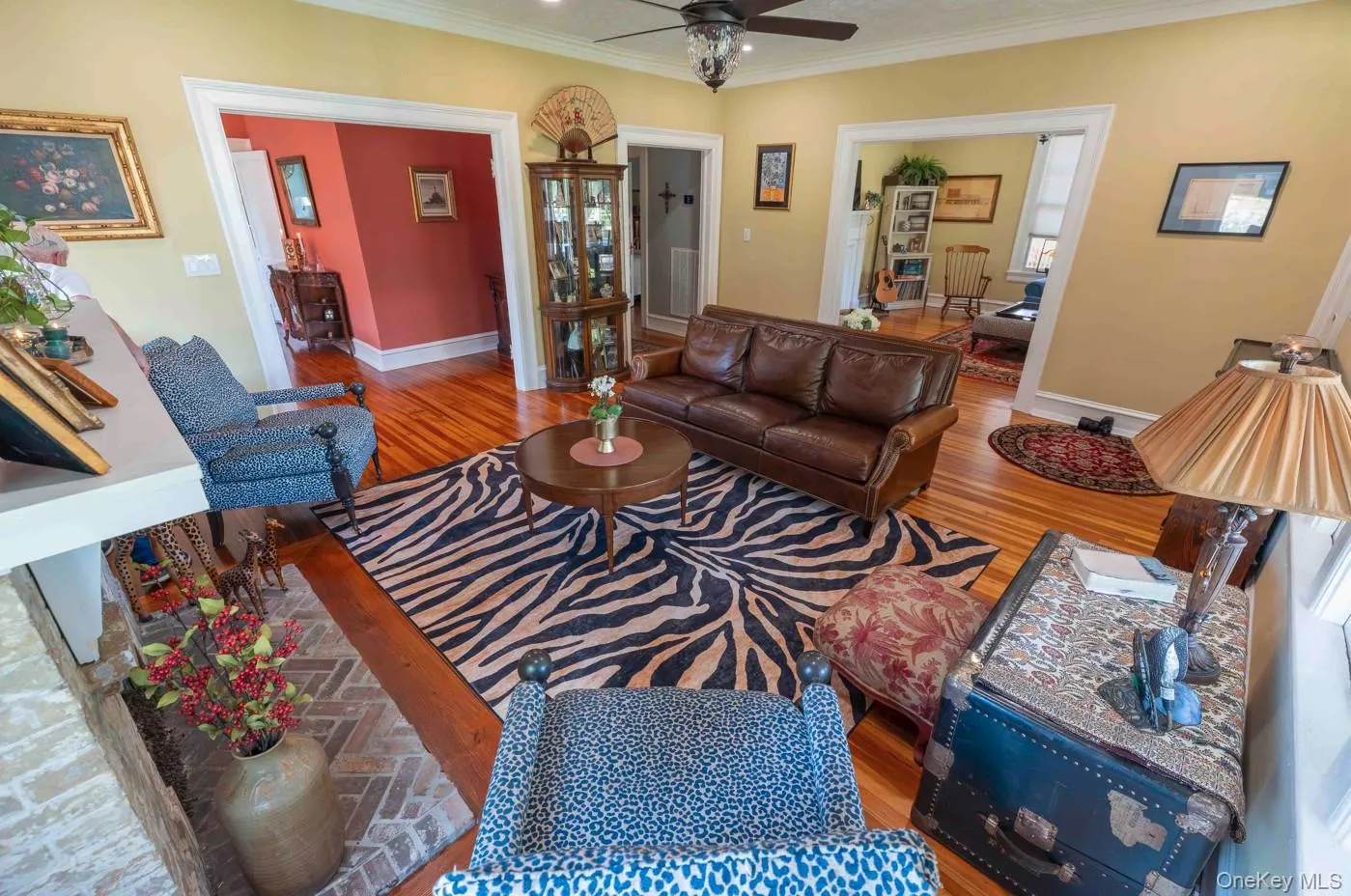 Living area featuring hardwood flooring, a ceiling fan, and crown molding Living area featuring hardwood flooring, a ceiling fan, and crown molding