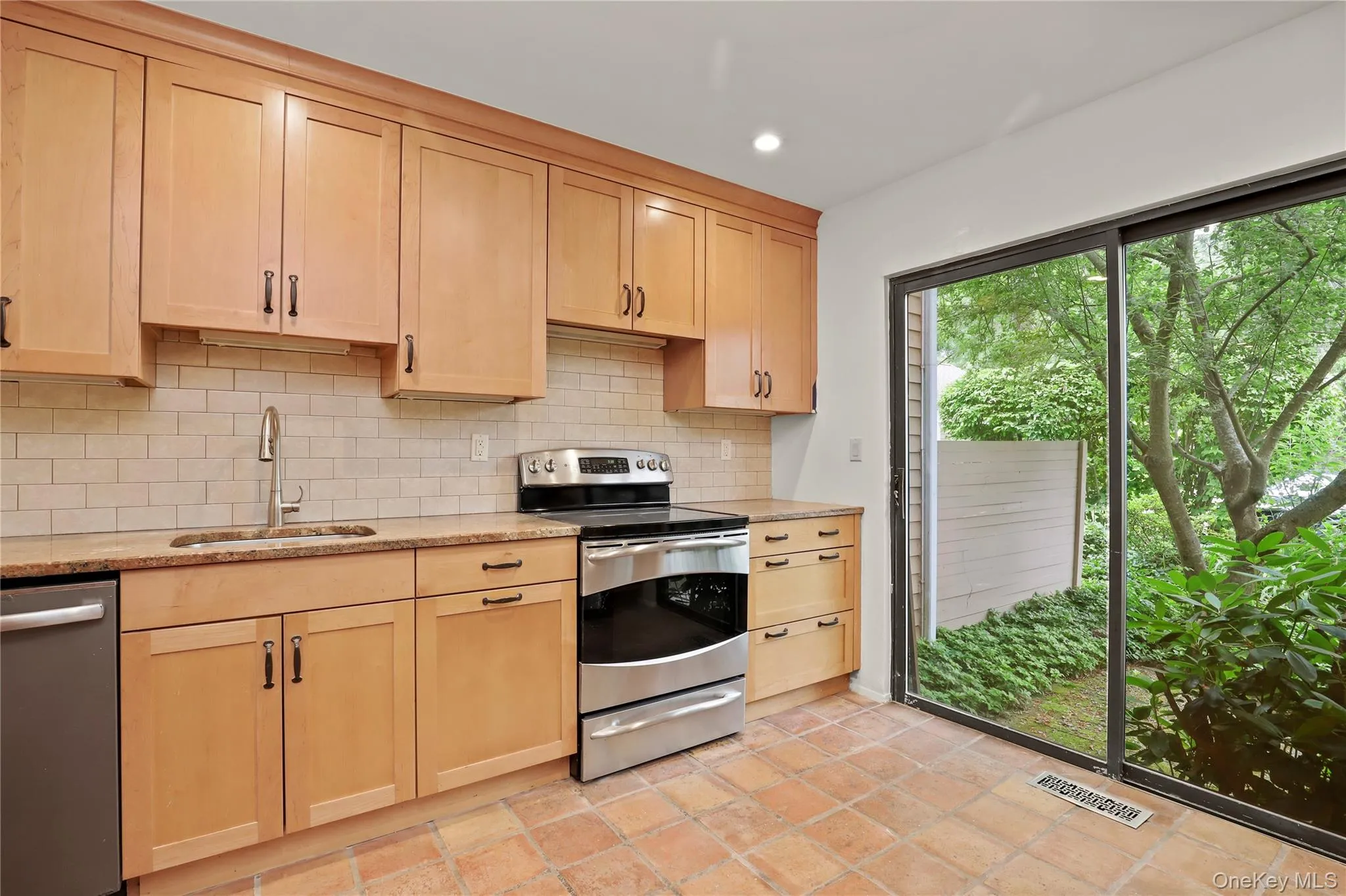 Kitchen with stainless steel appliances, a sink, light brown cabinets, tasteful backsplash, and recessed lighting Kitchen with stainless steel appliances, a sink, light brown cabinets, tasteful backsplash, and recessed lighting