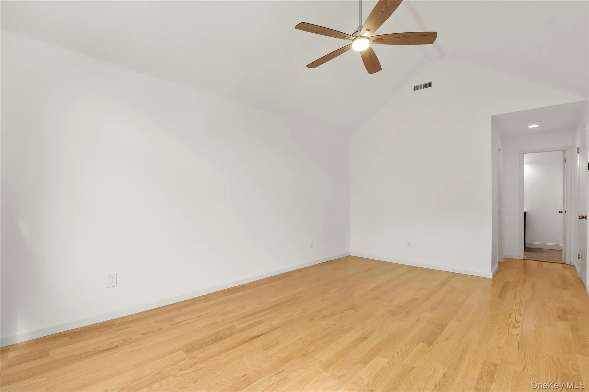 Unfurnished room with ceiling fan, lofted ceiling, light wood-style flooring, baseboards, and recessed lighting Unfurnished room with ceiling fan, lofted ceiling, light wood-style flooring, baseboards, and recessed lighting