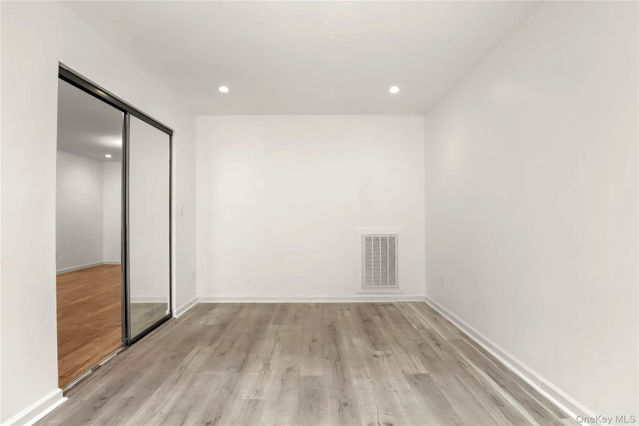 Unfurnished room with light wood-type flooring, recessed lighting, and baseboards Unfurnished room with light wood-type flooring, recessed lighting, and baseboards