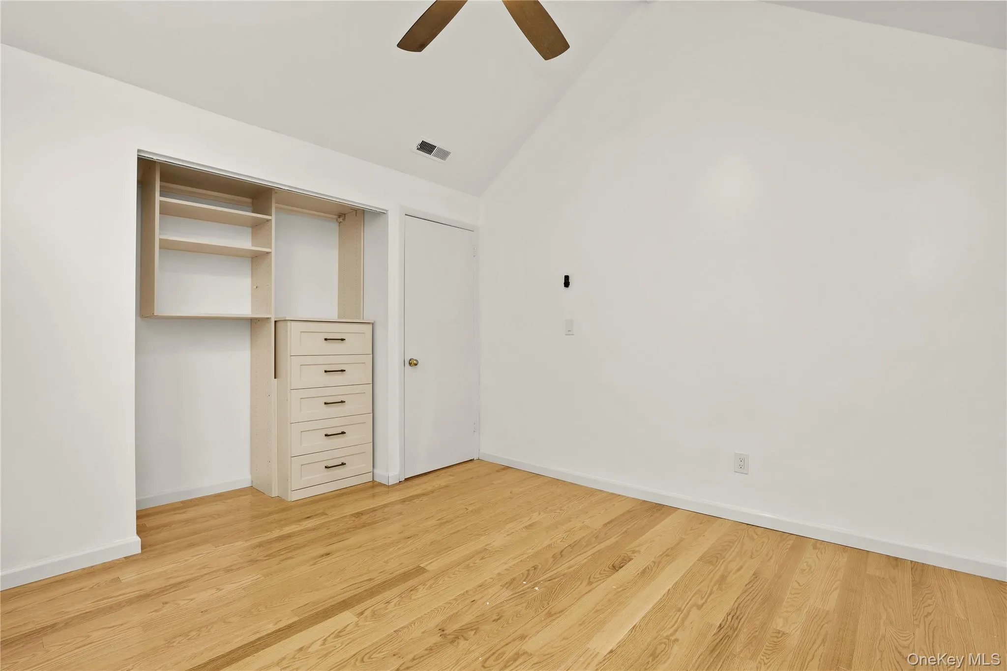 Unfurnished bedroom featuring vaulted ceiling, light wood finished floors, baseboards, and ceiling fan Unfurnished bedroom featuring vaulted ceiling, light wood finished floors, baseboards, and ceiling fan
