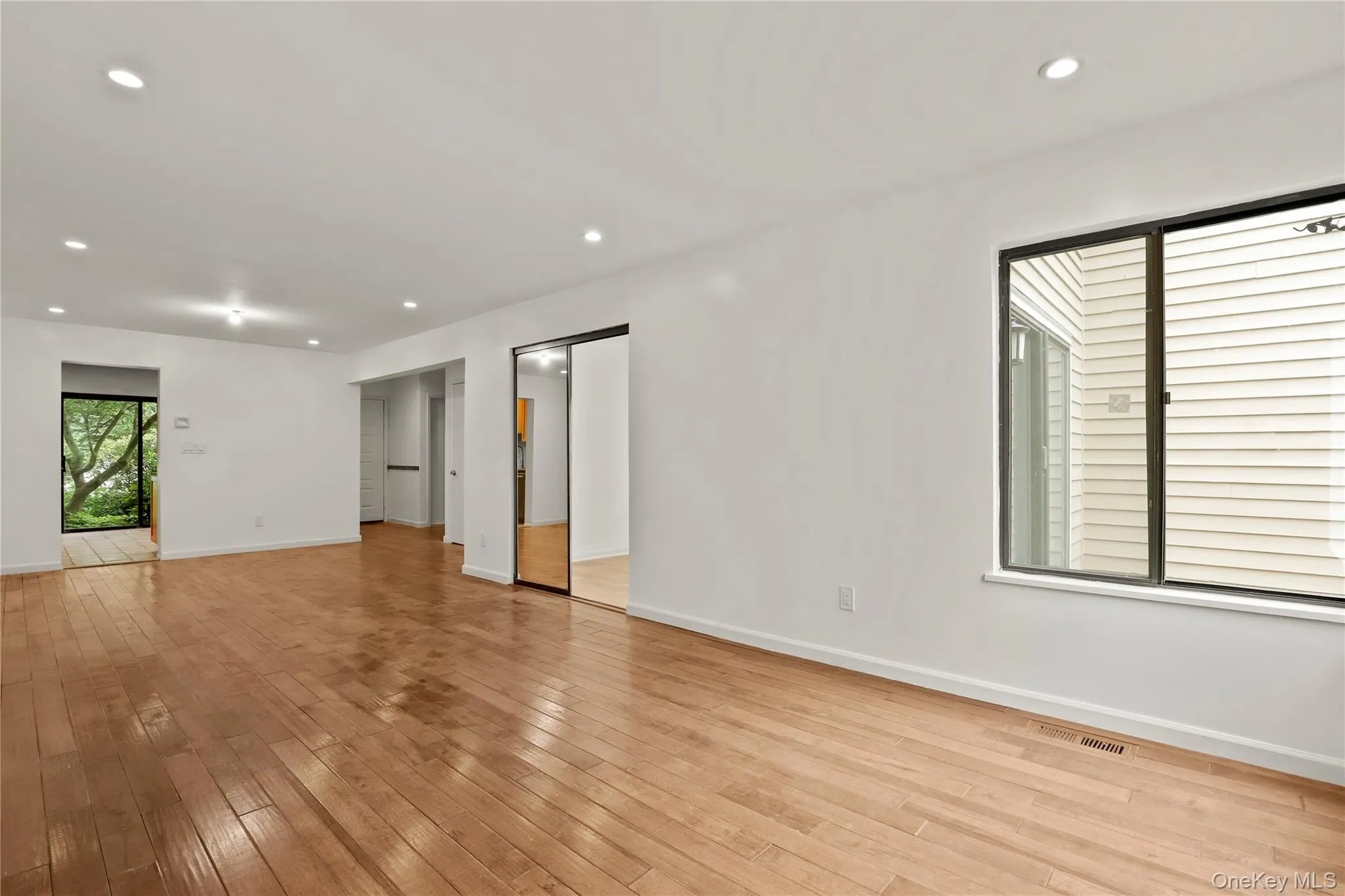 Empty room with baseboards, light wood-style flooring, and recessed lighting Empty room with baseboards, light wood-style flooring, and recessed lighting