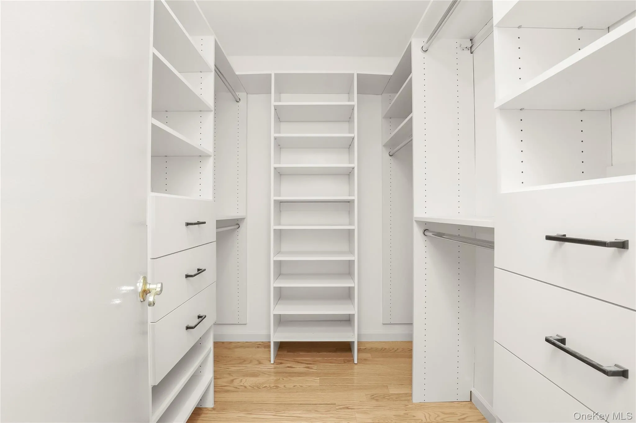 Walk in closet featuring light wood finished floors Walk in closet featuring light wood finished floors