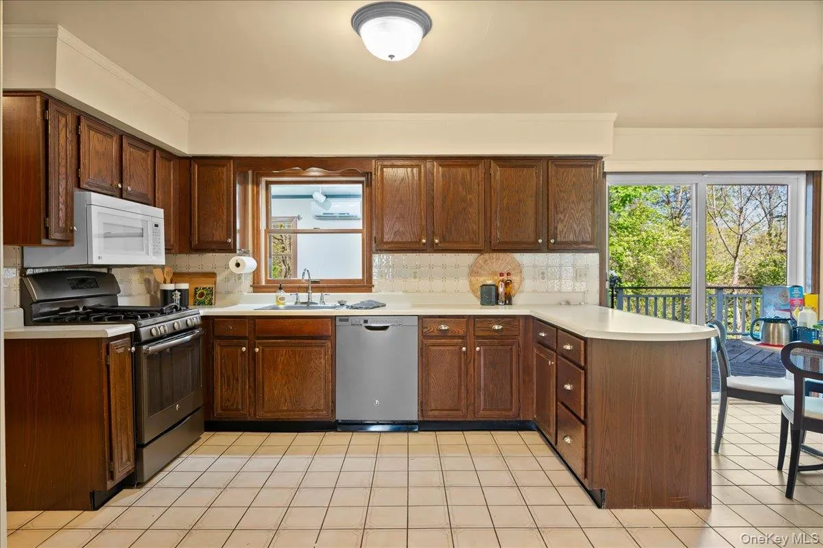 a SS French-door refrigerator, 5-burner gas range, and dishwasher, plus a wall-mounted microwave. a SS French-door refrigerator, 5-burner gas range, and dishwasher, plus a wall-mounted microwave.
