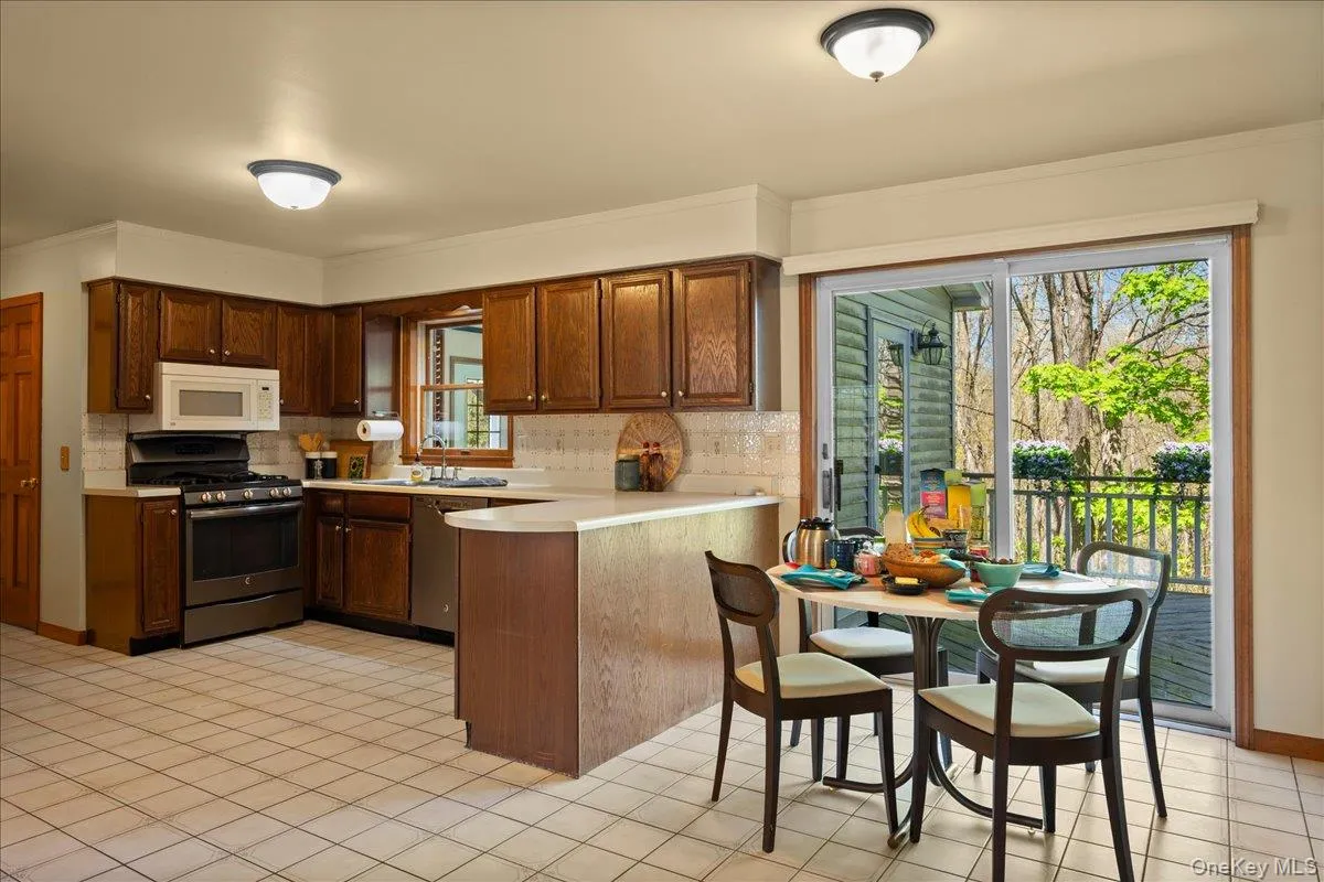 This eat-in, "heart of the home" kitchen has lots of counter space, a tiled floor and backsplash . . . This eat-in, "heart of the home" kitchen has lots of counter space, a tiled floor and backsplash . . .