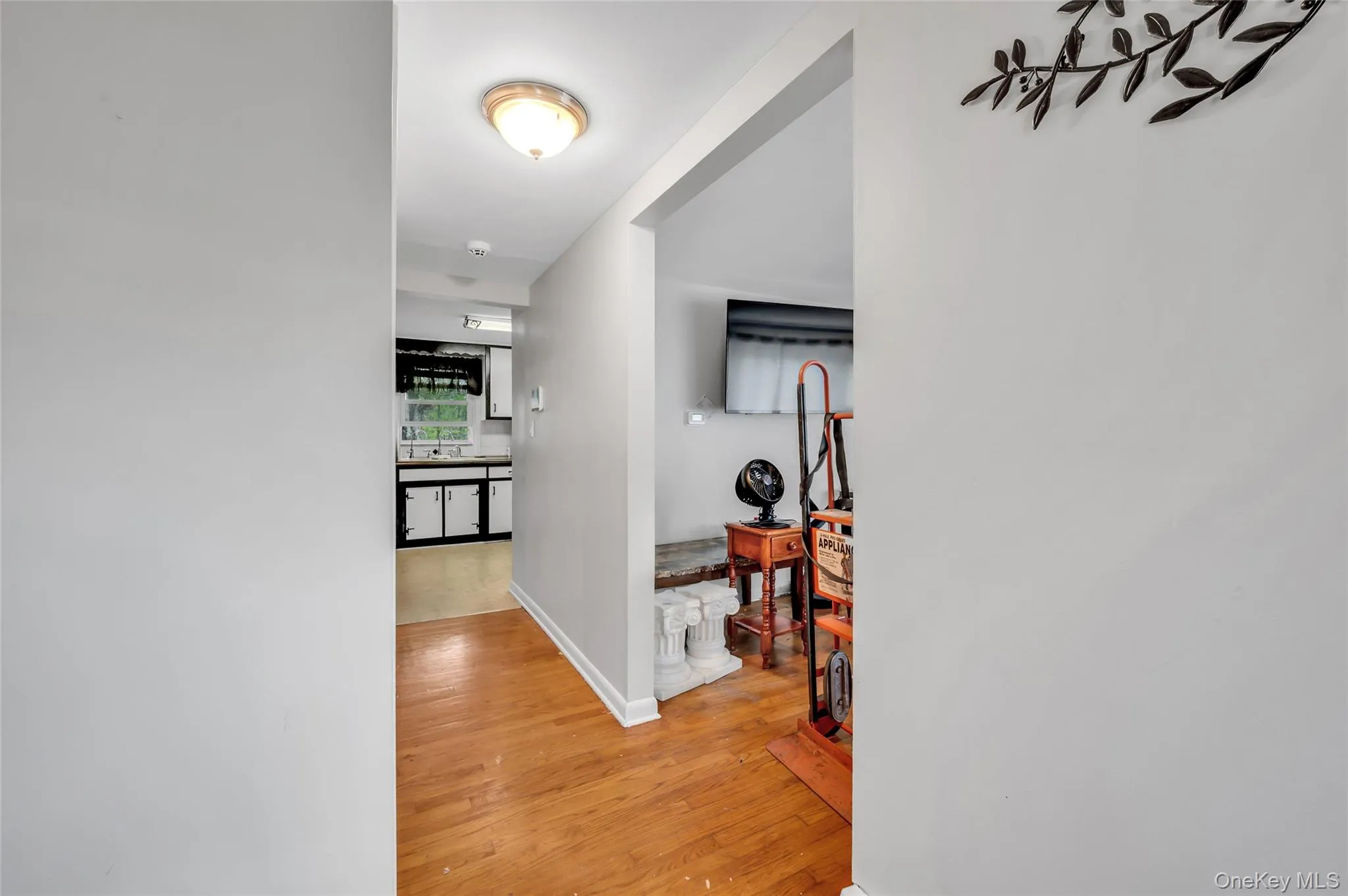 Hallway with wood-finish flooring and light-toned walls Hallway with wood-finish flooring and light-toned walls