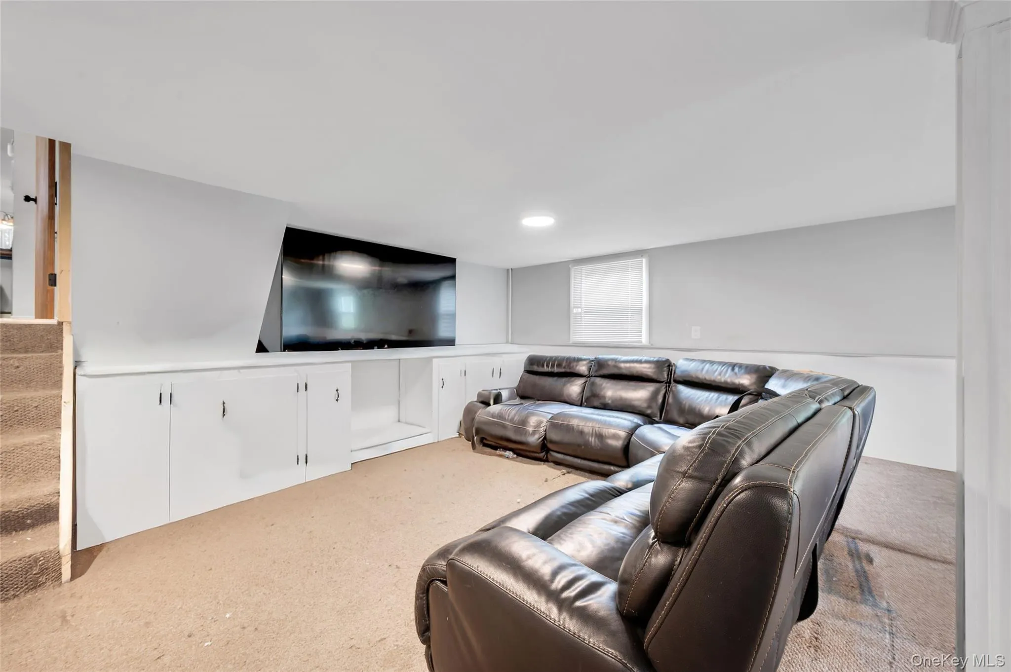 Finished lower level featuring recessed lighting, a built-in entertainment center, ample storage cabinetry, and a window for natural light Finished lower level featuring recessed lighting, a built-in entertainment center, ample storage cabinetry, and a window for natural light