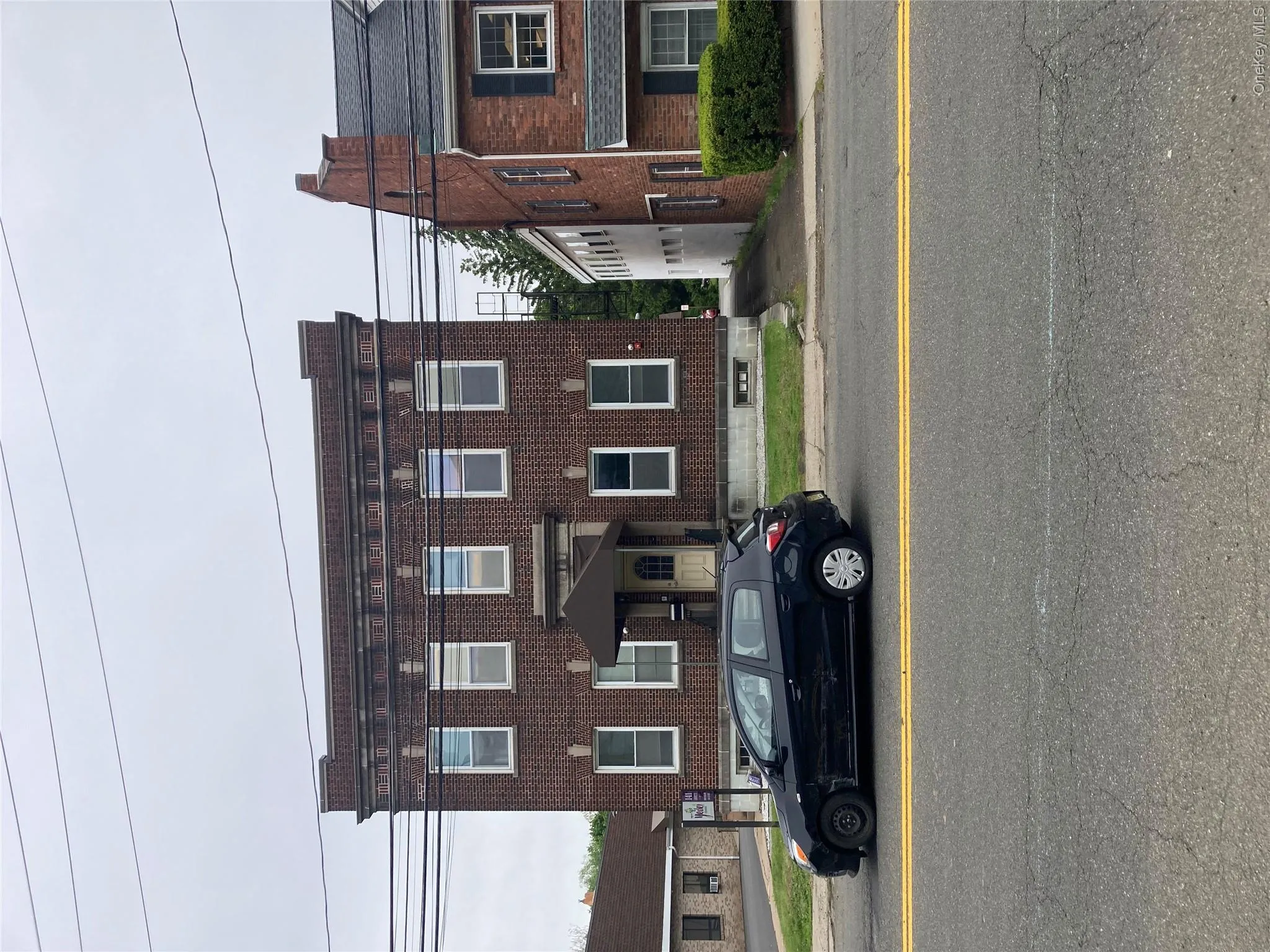 Brick building featuring a prominent entry with an awning Brick building featuring a prominent entry with an awning