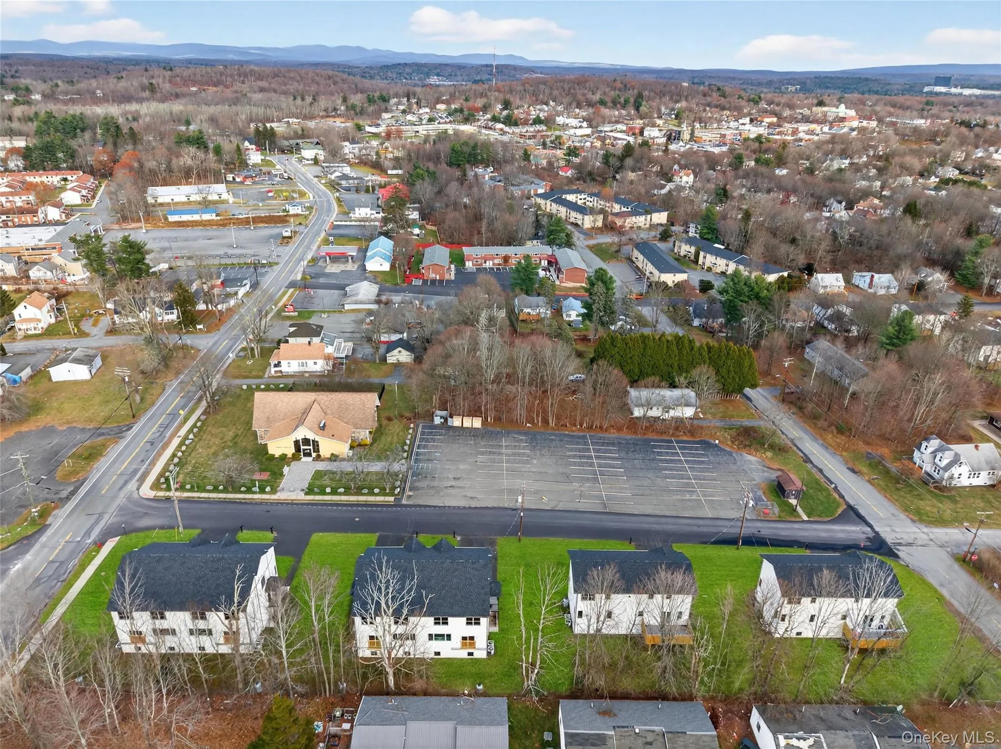 Aerial view of property and surrounding area featuring nearby suburban area and a mountainous background Aerial view of property and surrounding area featuring nearby suburban area and a mountainous background