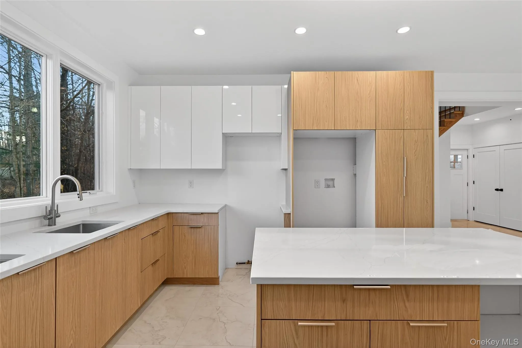 Kitchen featuring modern cabinets, light stone counters, white cabinetry, recessed lighting, and light marble finish floors Kitchen featuring modern cabinets, light stone counters, white cabinetry, recessed lighting, and light marble finish floors