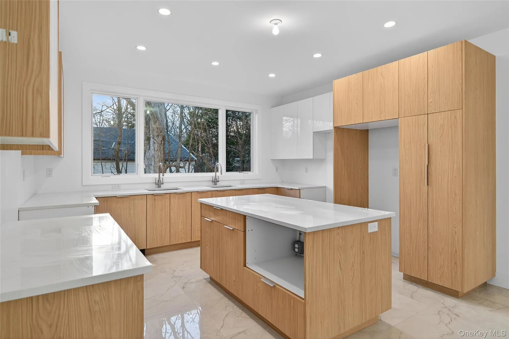 Kitchen with light marble finish flooring, modern cabinets, light stone counters, recessed lighting, and a center island Kitchen with light marble finish flooring, modern cabinets, light stone counters, recessed lighting, and a center island