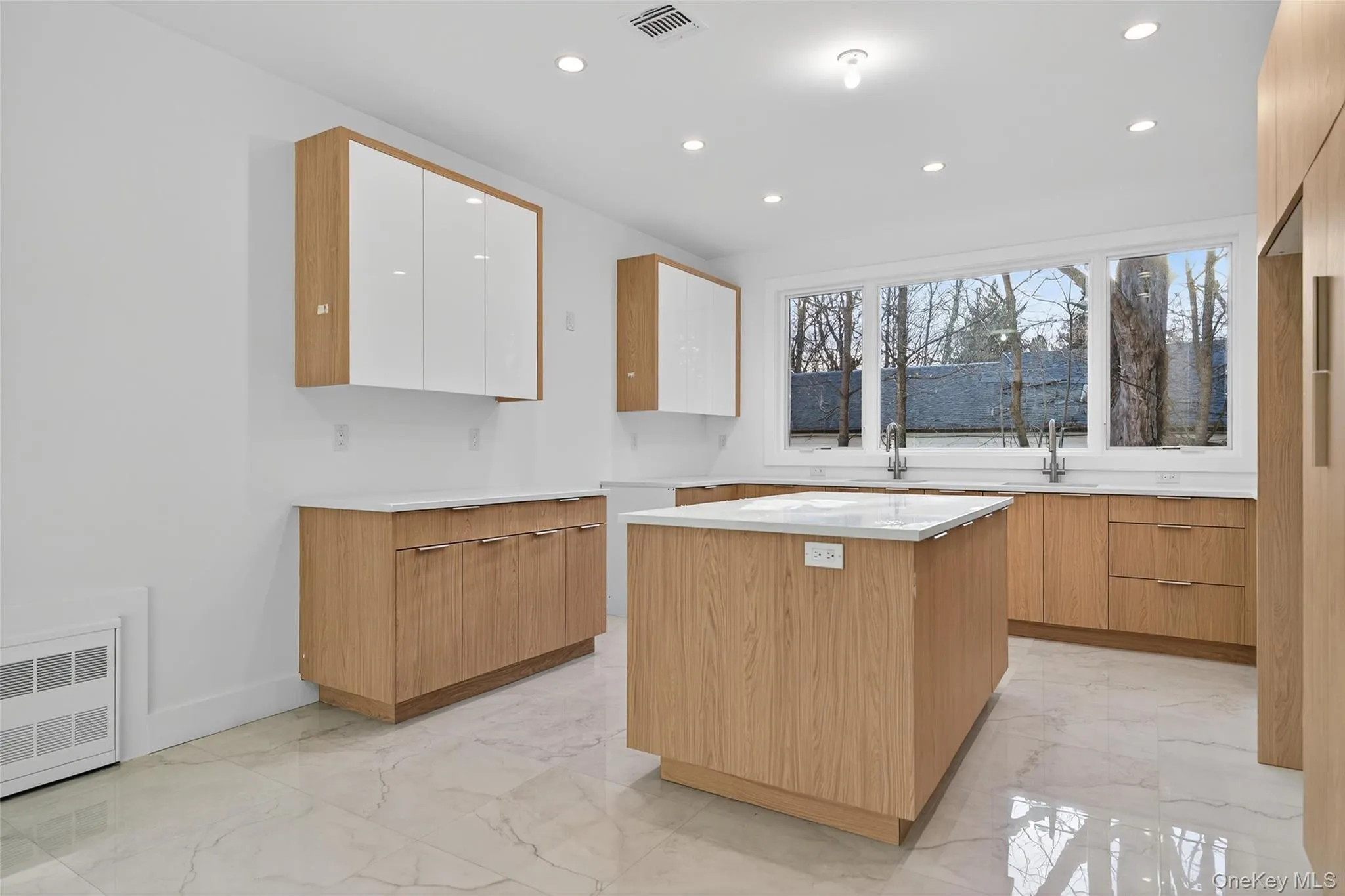 Kitchen featuring light marble finish floors, recessed lighting, a center island, modern cabinets, and white cabinetry Kitchen featuring light marble finish floors, recessed lighting, a center island, modern cabinets, and white cabinetry