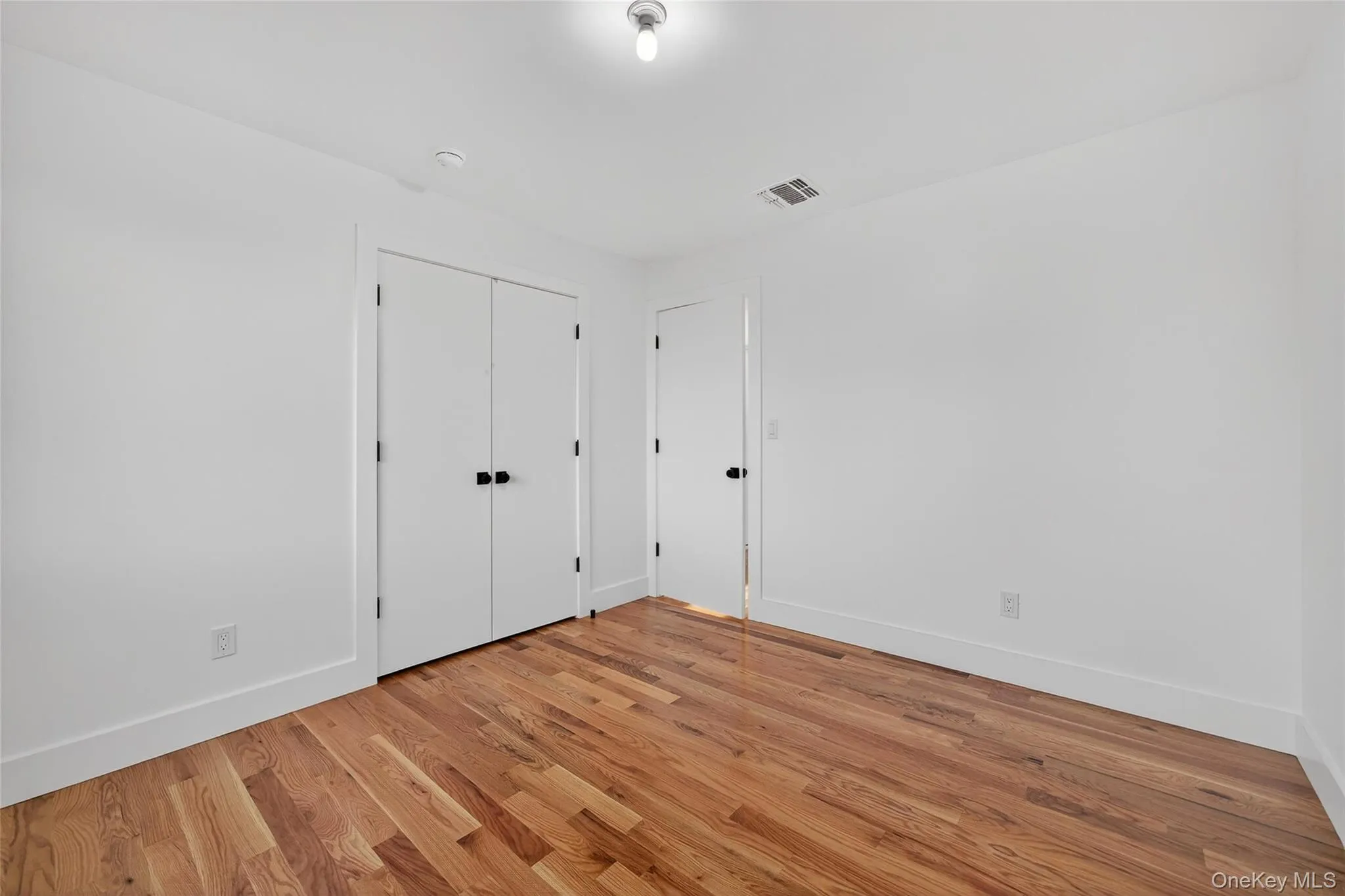 Unfurnished bedroom featuring light wood-style flooring and a closet Unfurnished bedroom featuring light wood-style flooring and a closet