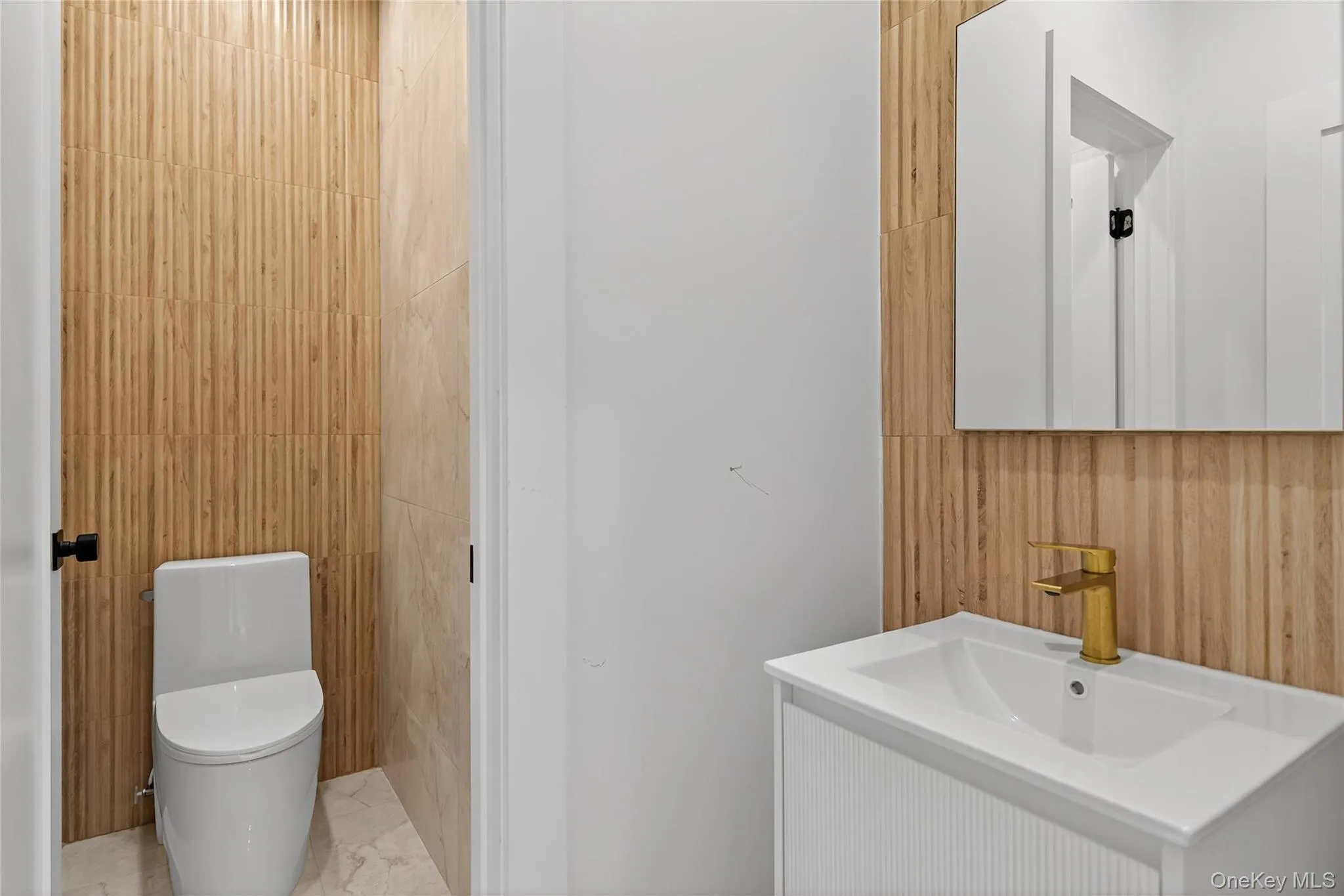 Bathroom featuring vanity and marble finish flooring Bathroom featuring vanity and marble finish flooring