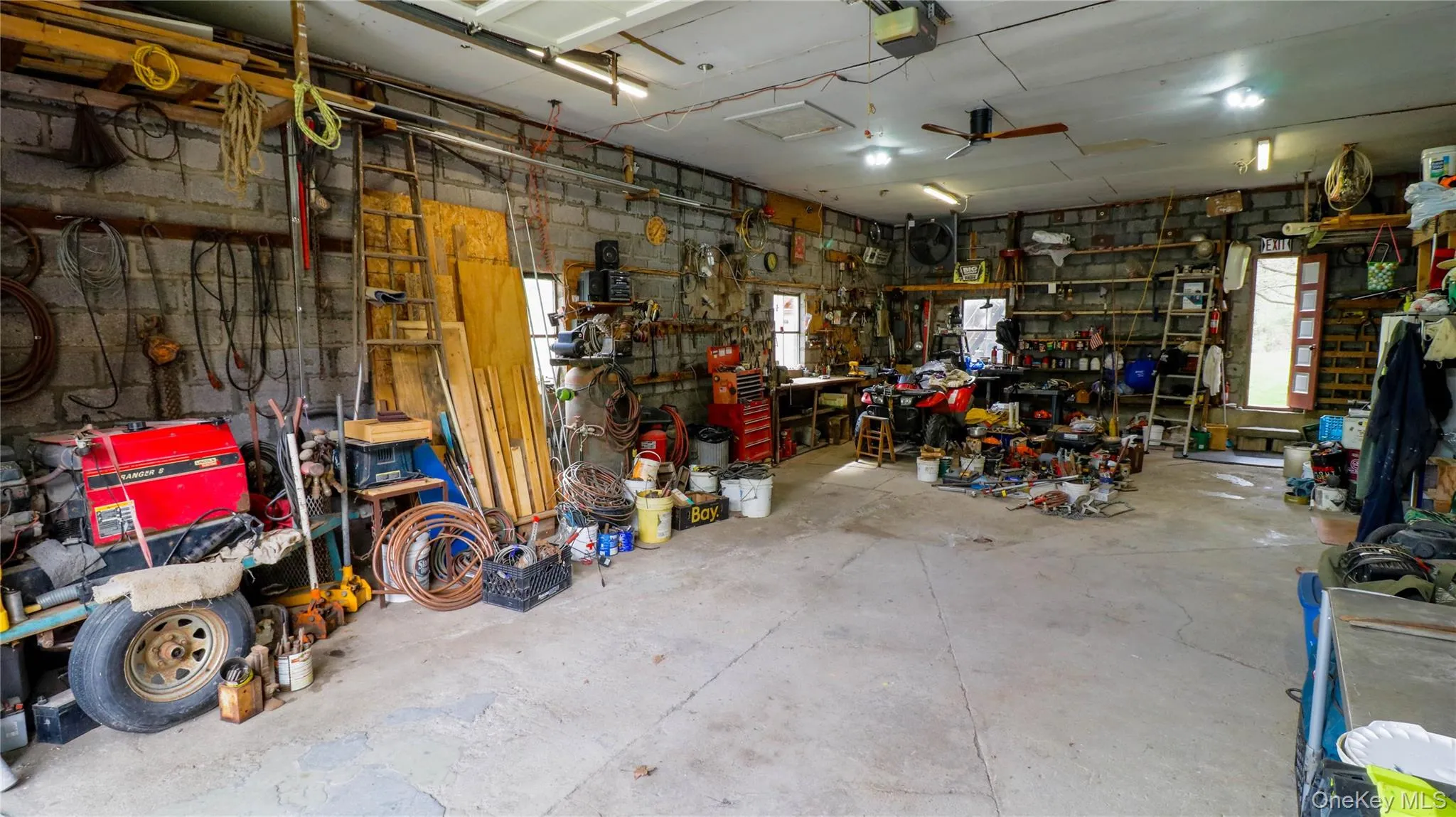 Spacious garage interior featuring concrete block walls and a concrete floor Spacious garage interior featuring concrete block walls and a concrete floor
