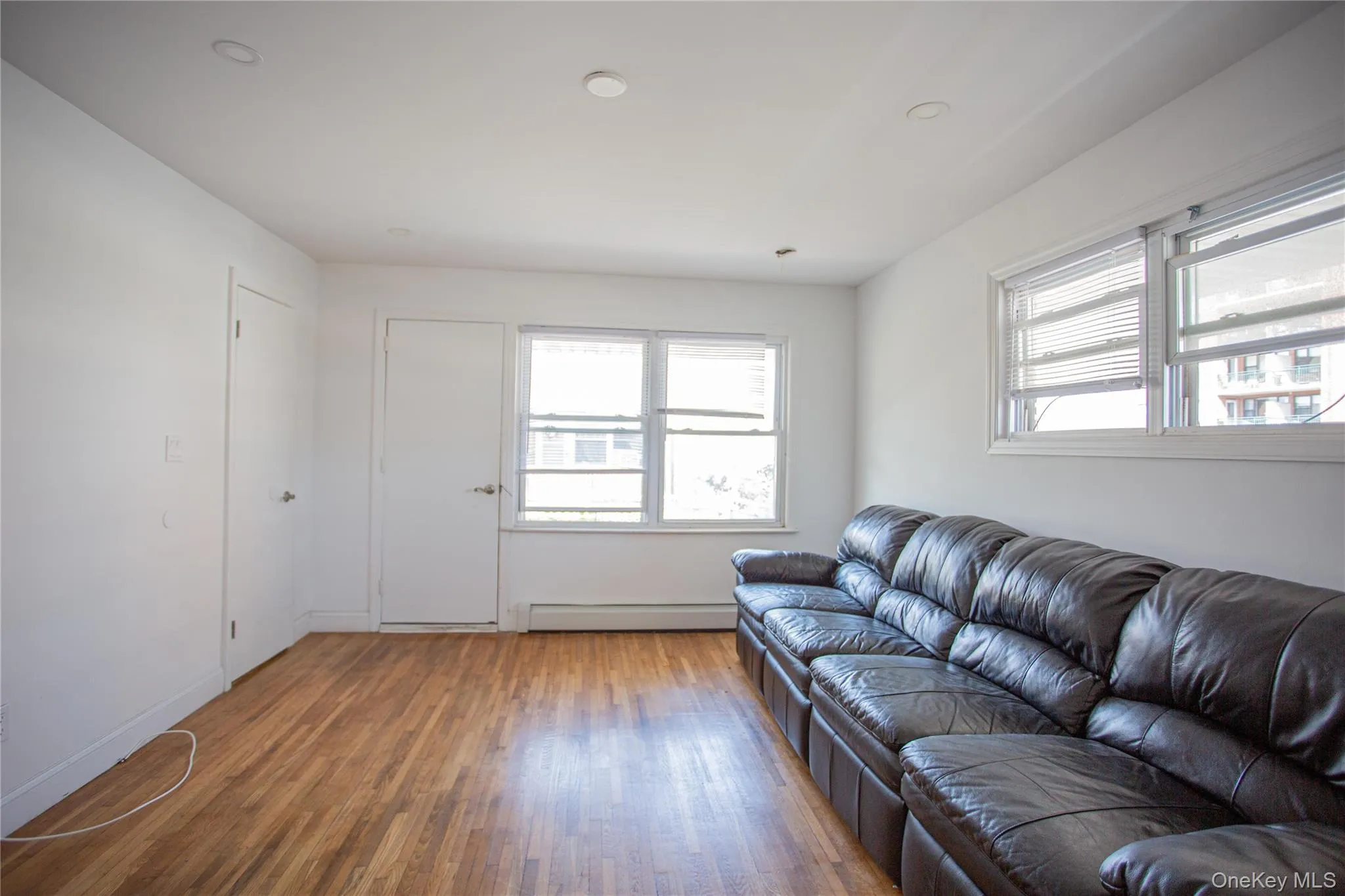 Living room featuring wood finished floors and baseboard heating Living room featuring wood finished floors and baseboard heating