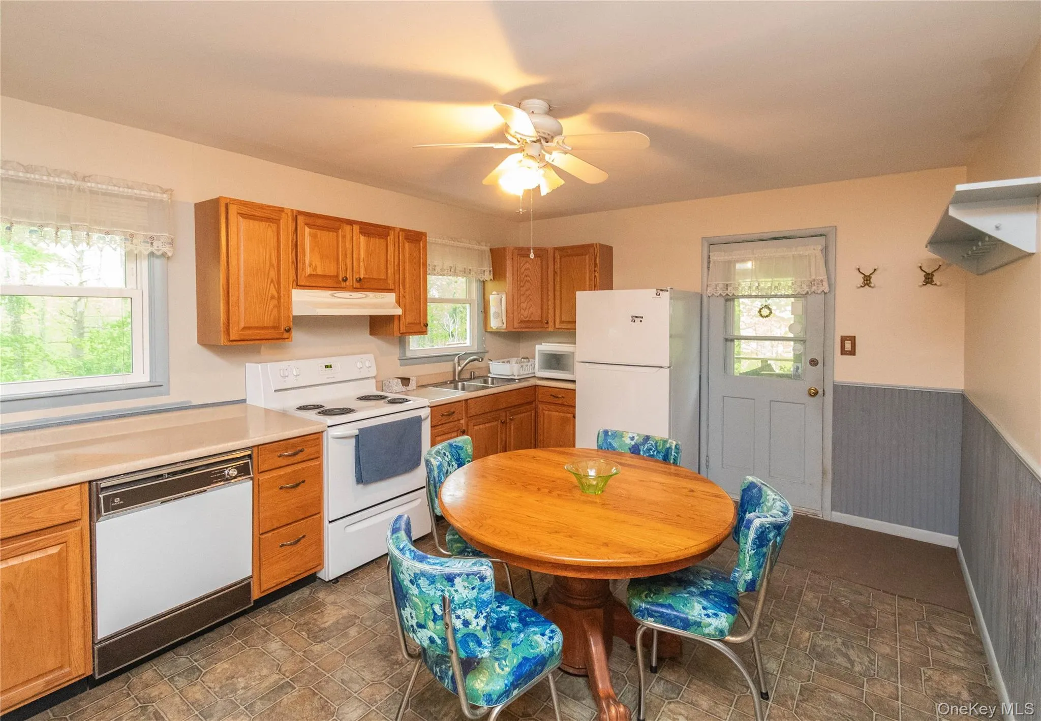 Eat in Kitchen featuring wood cabinetry, laminate countertops, vinyl flooring, and a ceiling fan Eat in Kitchen featuring wood cabinetry, laminate countertops, vinyl flooring, and a ceiling fan