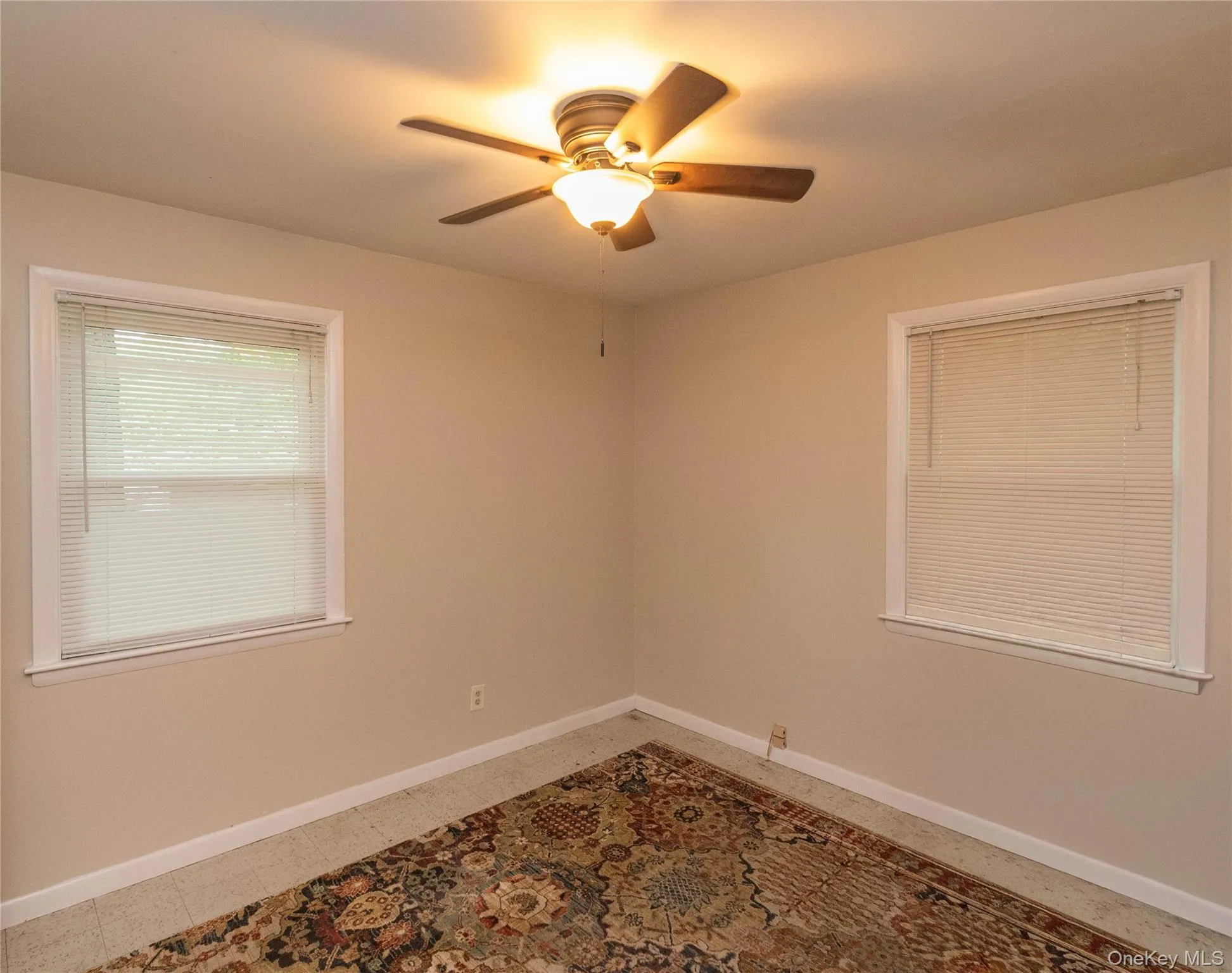 Neutral wall tones with white trim, two windows, and a ceiling fan Neutral wall tones with white trim, two windows, and a ceiling fan