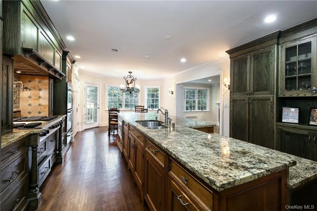 Chef's kitchen with custom cabinetry, top-of-the line stainless appliances and seating at either the island or the table near the window. Appliances include a Thermador double wall oven and warming drawer, built-in microwave, 6-burner Viking cooktop with griddle and pot filler, Sub-Zero refrigerator and large island with granite countertops. Chef's kitchen with custom cabinetry, top-of-the line stainless appliances and seating at either the island or the table near the window. Appliances include a Thermador double wall oven and warming drawer, built-in microwave, 6-burner Viking cooktop with griddle and pot filler, Sub-Zero refrigerator and large island with granite countertops.
