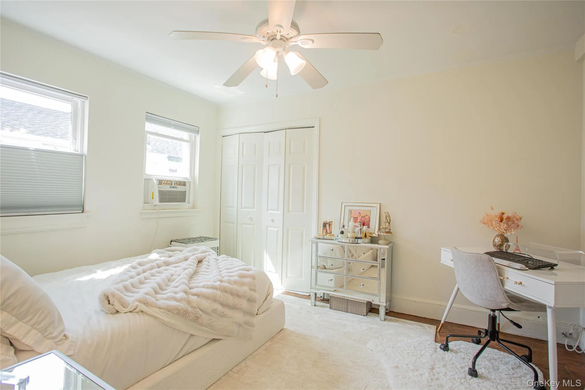 Bedroom featuring a closet, ceiling fan, cooling unit, and wood finished floors Bedroom featuring a closet, ceiling fan, cooling unit, and wood finished floors