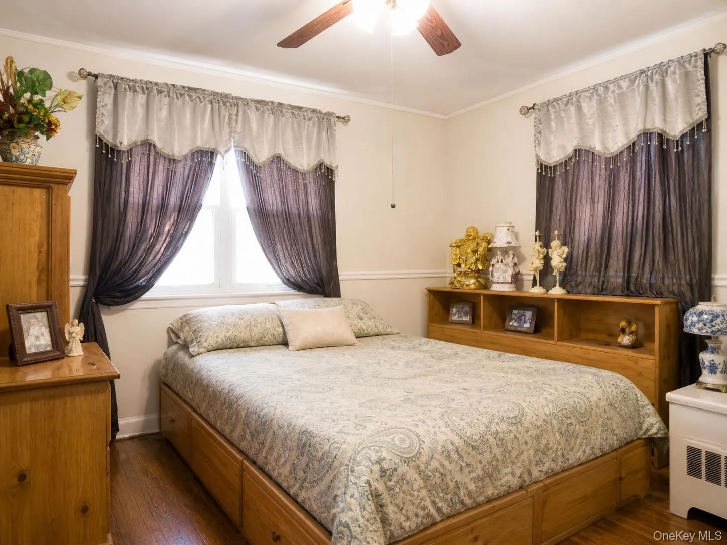 Bedroom featuring a ceiling fan, crown molding, and wood-finish flooring Bedroom featuring a ceiling fan, crown molding, and wood-finish flooring