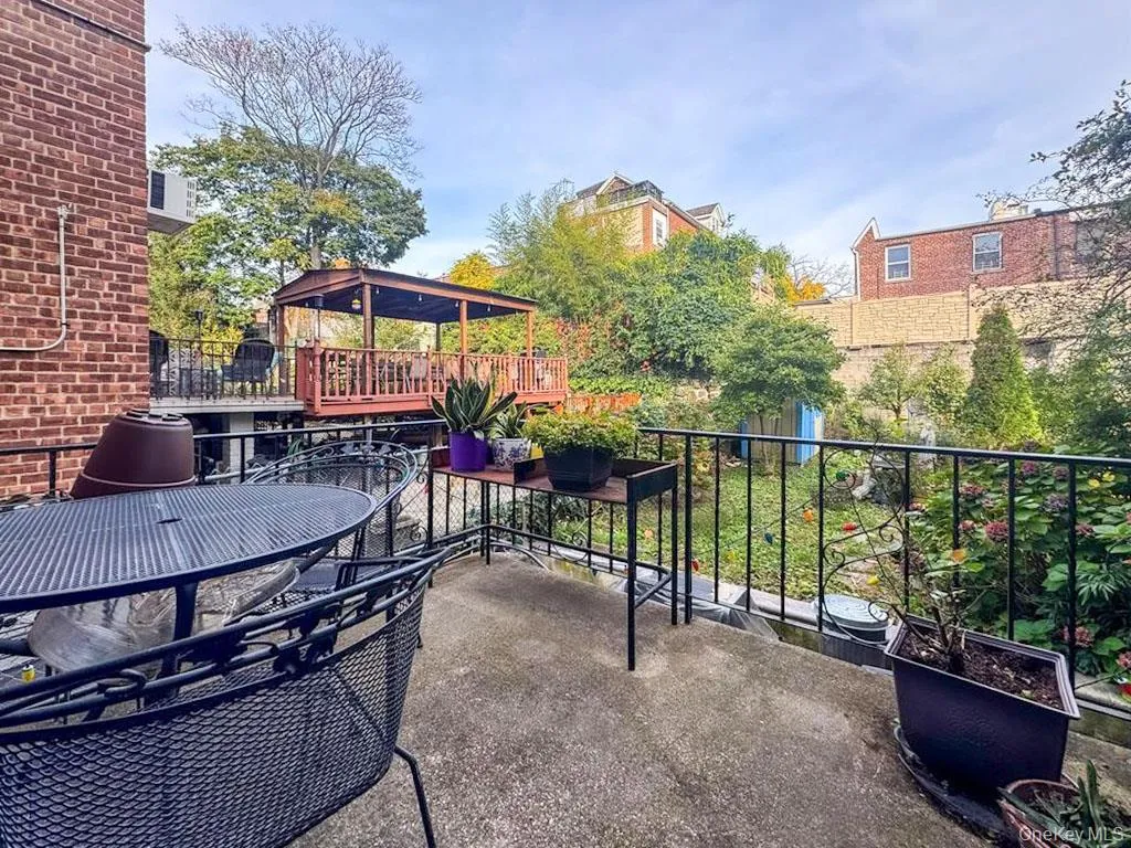 Concrete backyard Deck with black metal railing overlooking a multi-level garden Concrete backyard Deck with black metal railing overlooking a multi-level garden