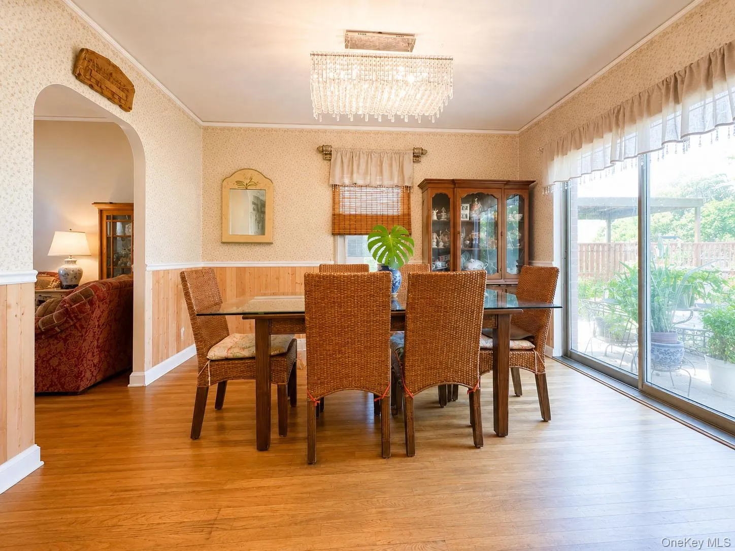 Dining area featuring wood-finish flooring, a crystal chandelier, and a sliding glass door to the exterior Dining area featuring wood-finish flooring, a crystal chandelier, and a sliding glass door to the exterior