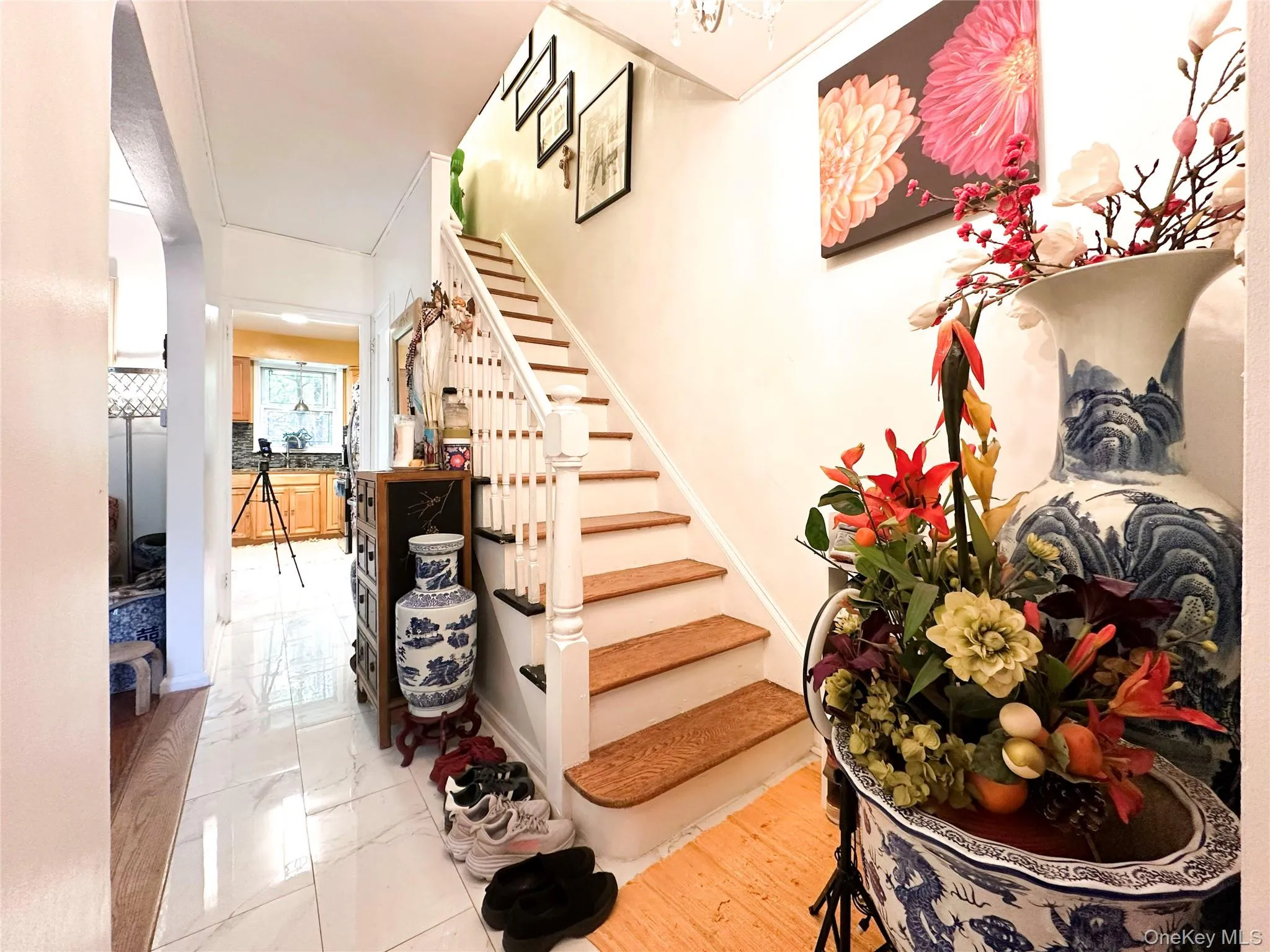 Bright entryway featuring a wooden staircase with white balusters and wood-finish treads Bright entryway featuring a wooden staircase with white balusters and wood-finish treads