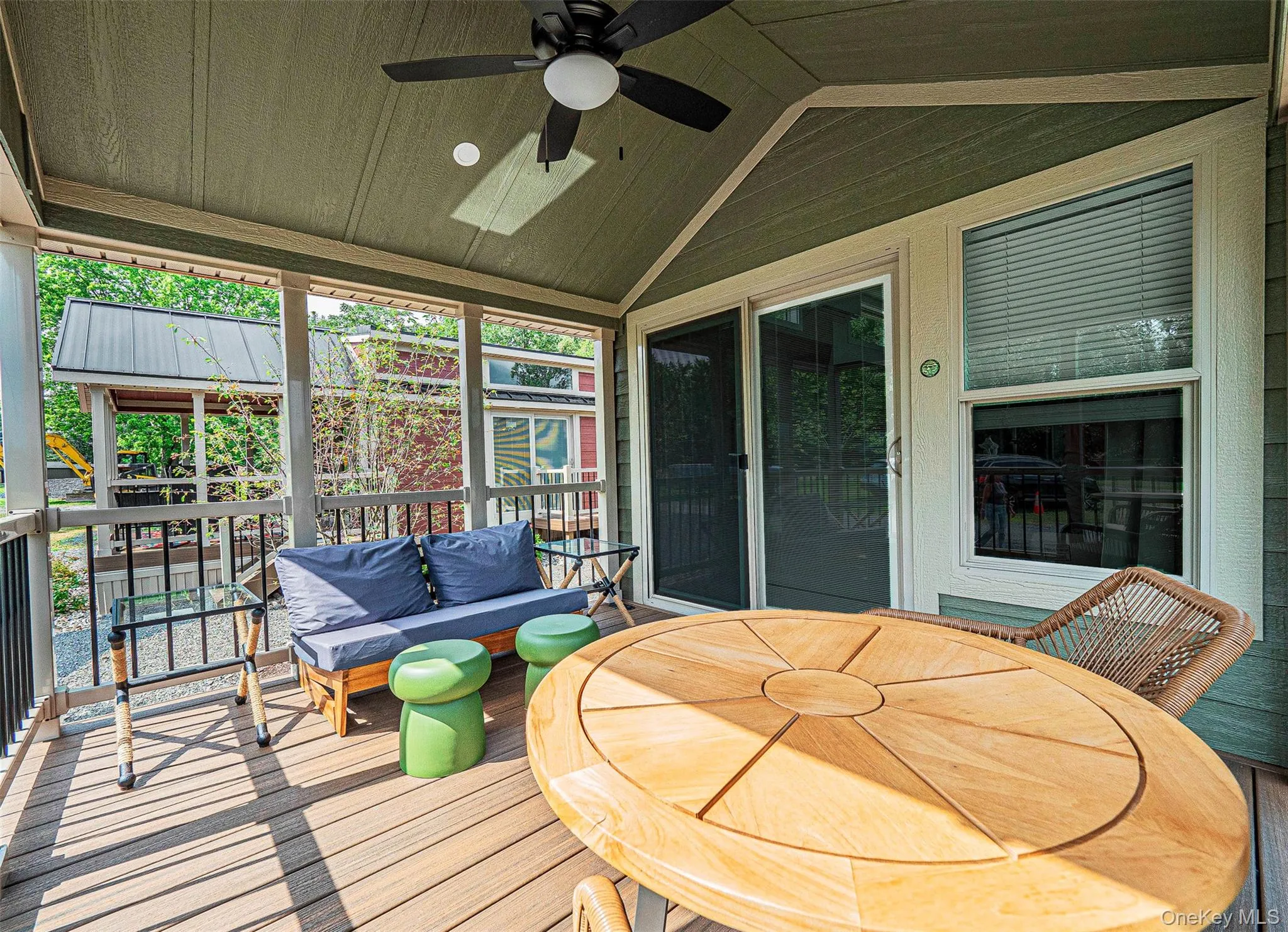 Covered porch featuring lofted ceiling, a ceiling fan, and a wooden deck Covered porch featuring lofted ceiling, a ceiling fan, and a wooden deck